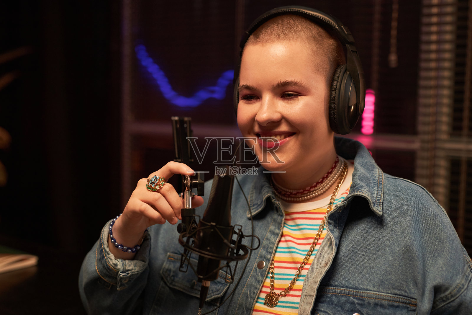 快乐的年轻女子使用演播室麦克风照片摄影图片