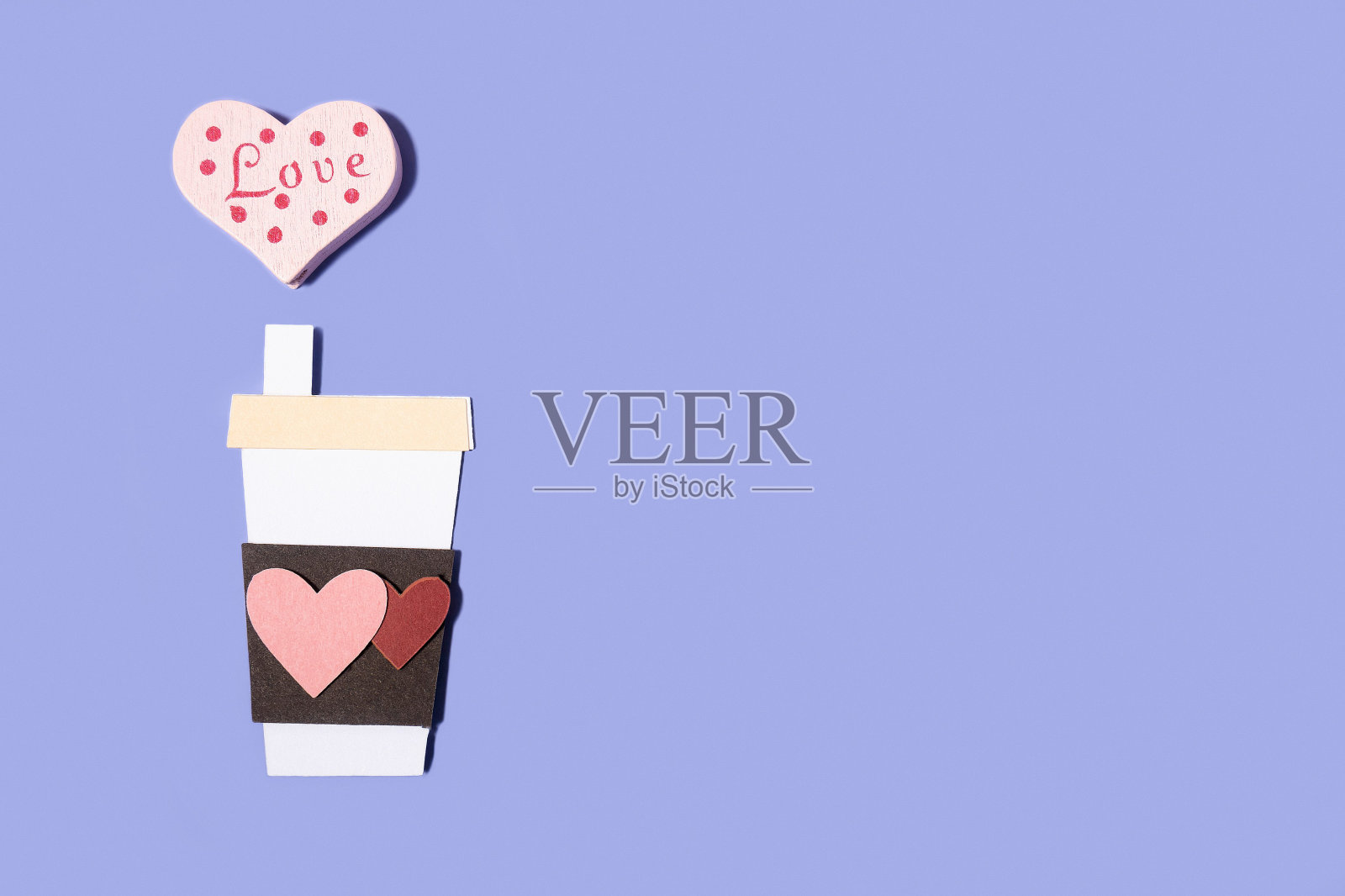 纸手工咖啡杯与心在柔和的蓝色背景。概念为情人节、母亲节、世界妇女节。浪漫的平面构图。照片摄影图片