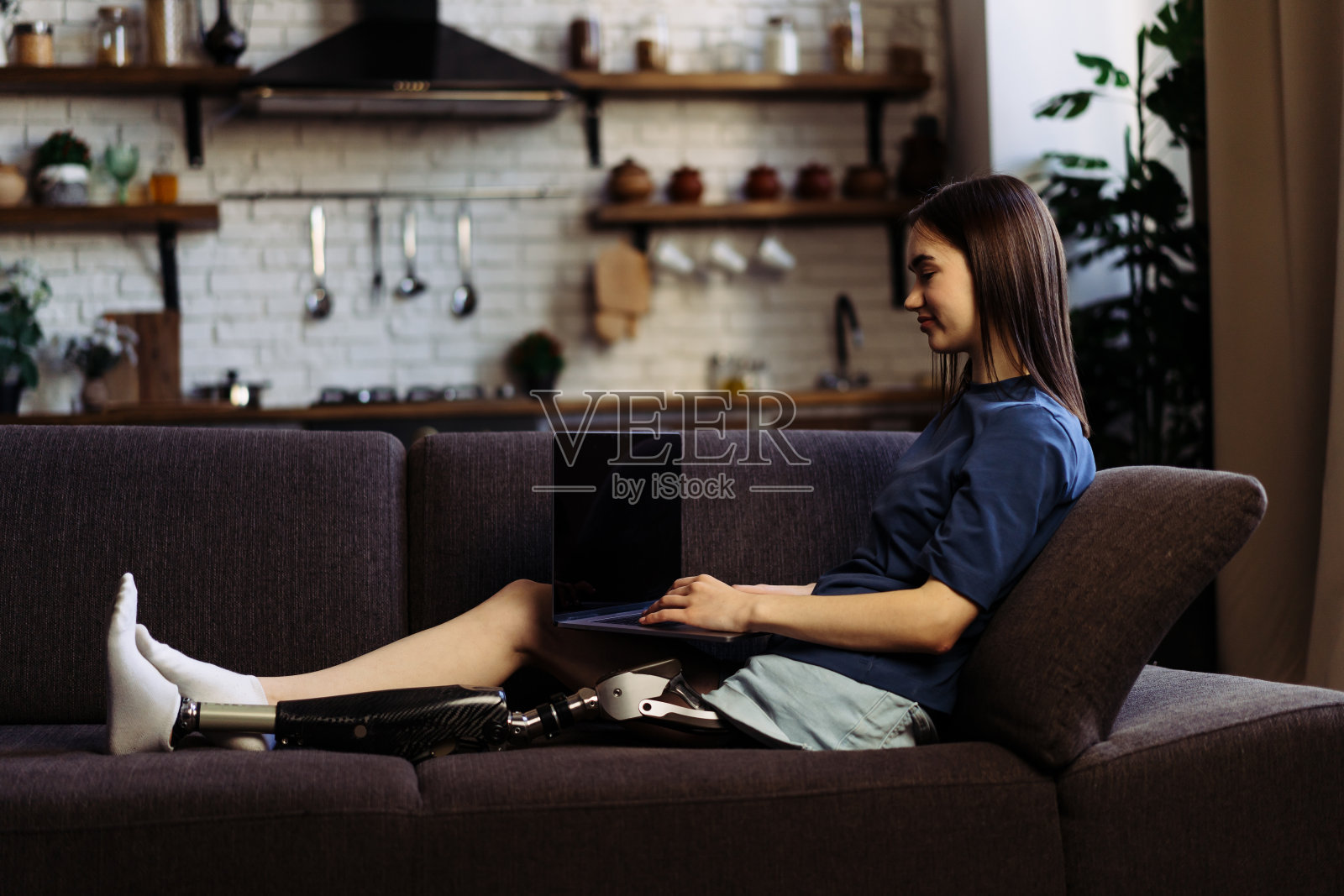 装有假肢的女士通过笔记本电脑与同事互动照片摄影图片