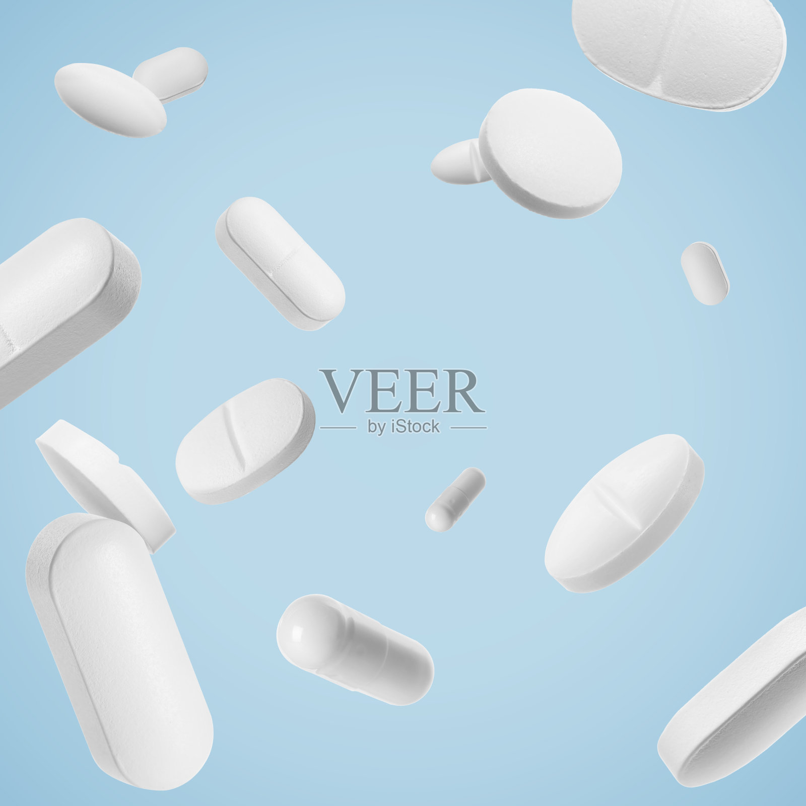 许多不同的药丸落在浅蓝色的背景上照片摄影图片