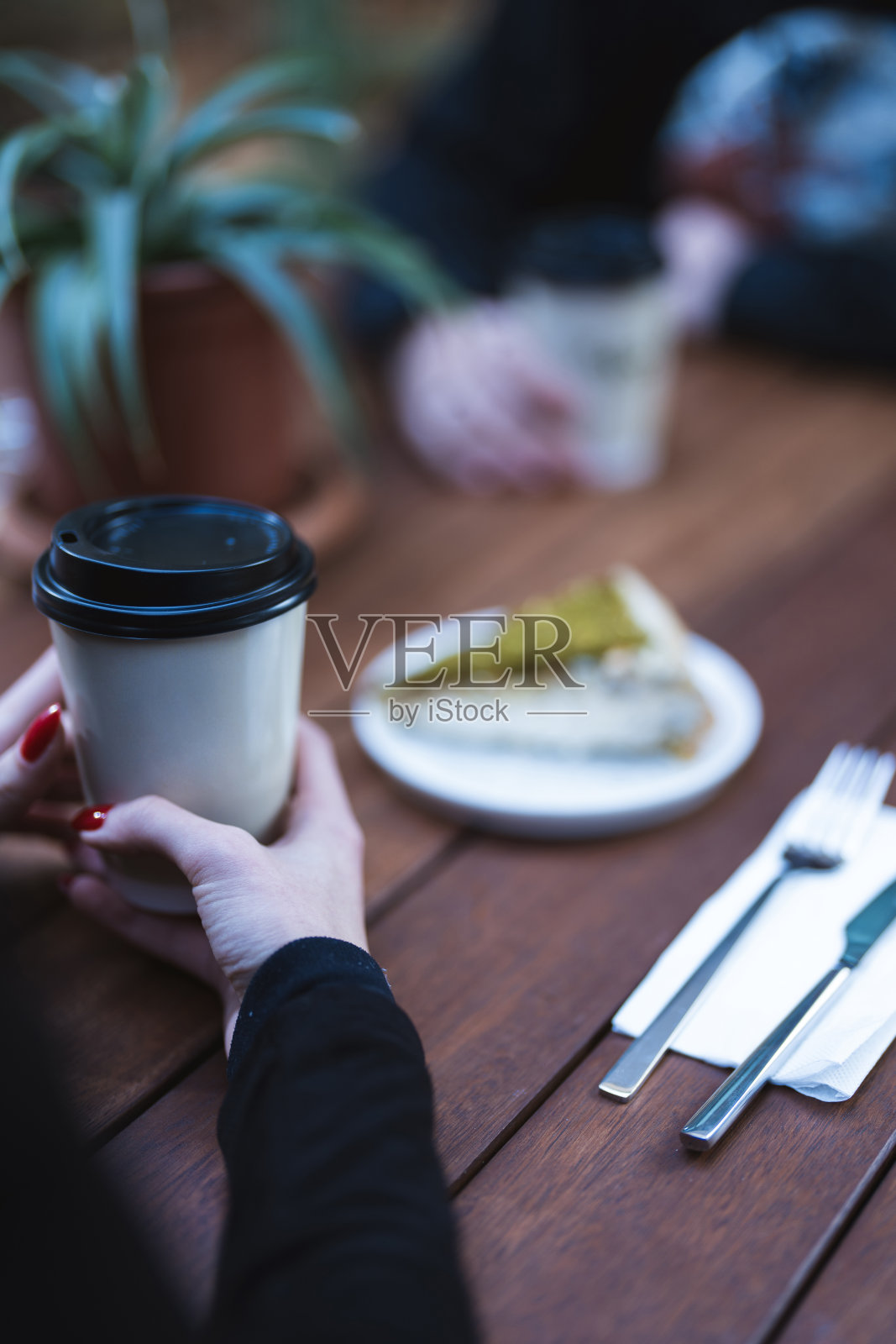 朋友们在咖啡馆的木桌旁喝咖啡，特写照片摄影图片