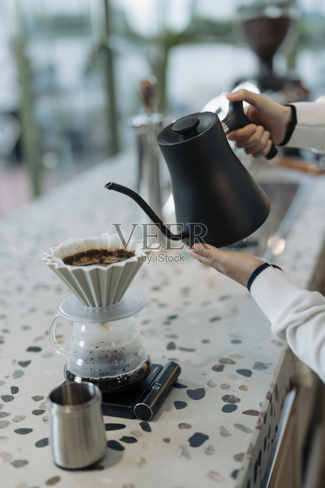 在现代咖啡馆里，女咖啡师正在用过滤器倒咖啡照片摄影图片