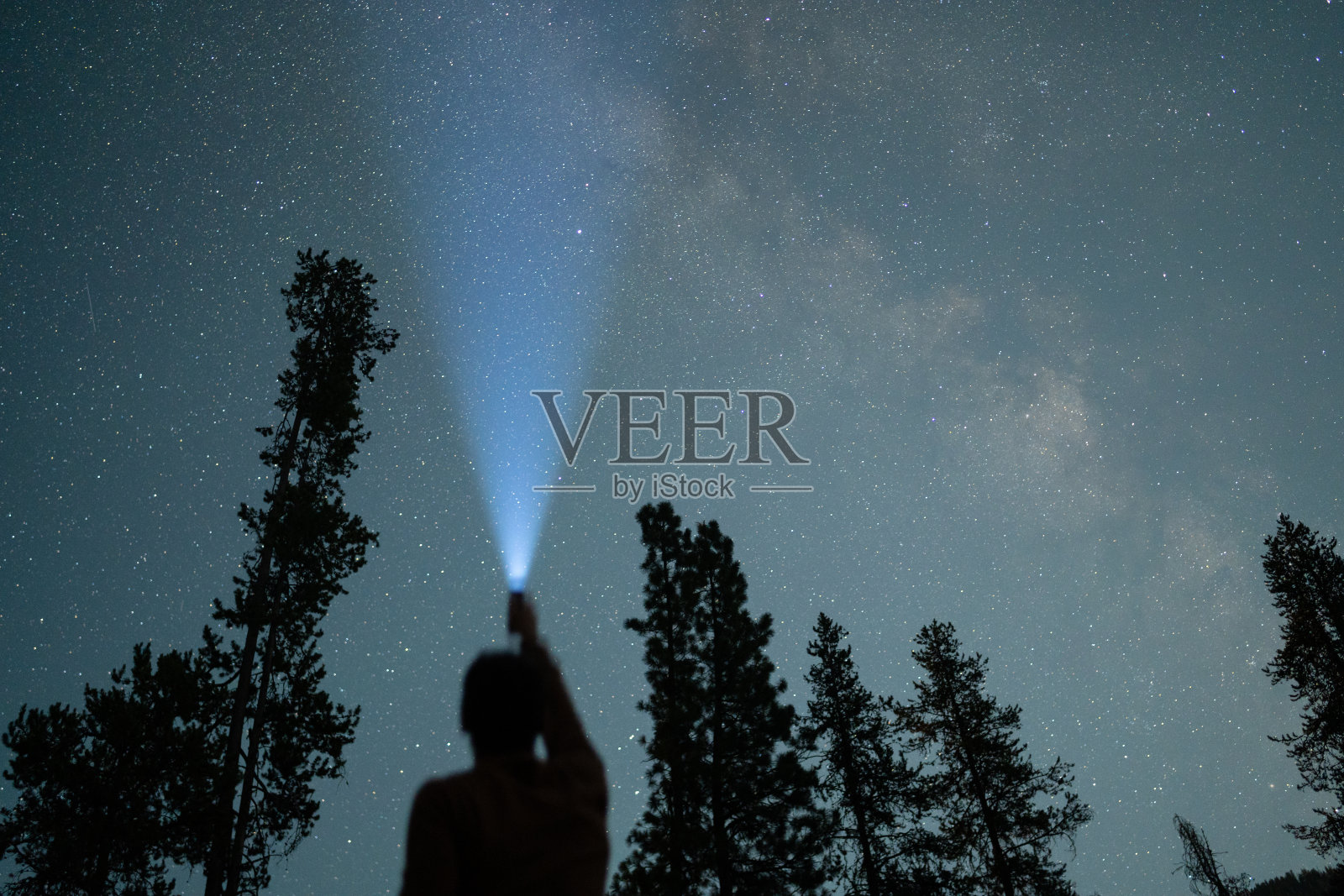 天文摄影的人拿着手电筒在银河系的肖像照片摄影图片