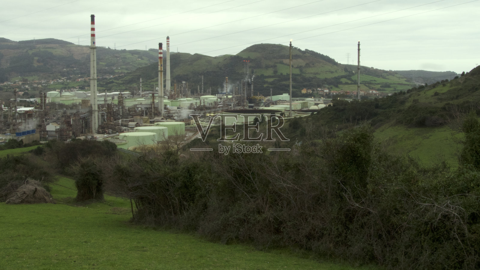 巴斯克地区群山之间的石油蒸馏厂照片摄影图片