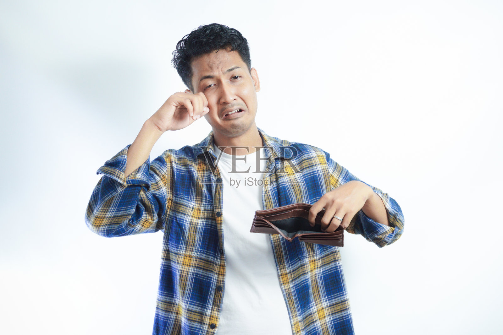 成年亚洲男子一边打开钱包，一边带着悲伤的表情看着镜头照片摄影图片