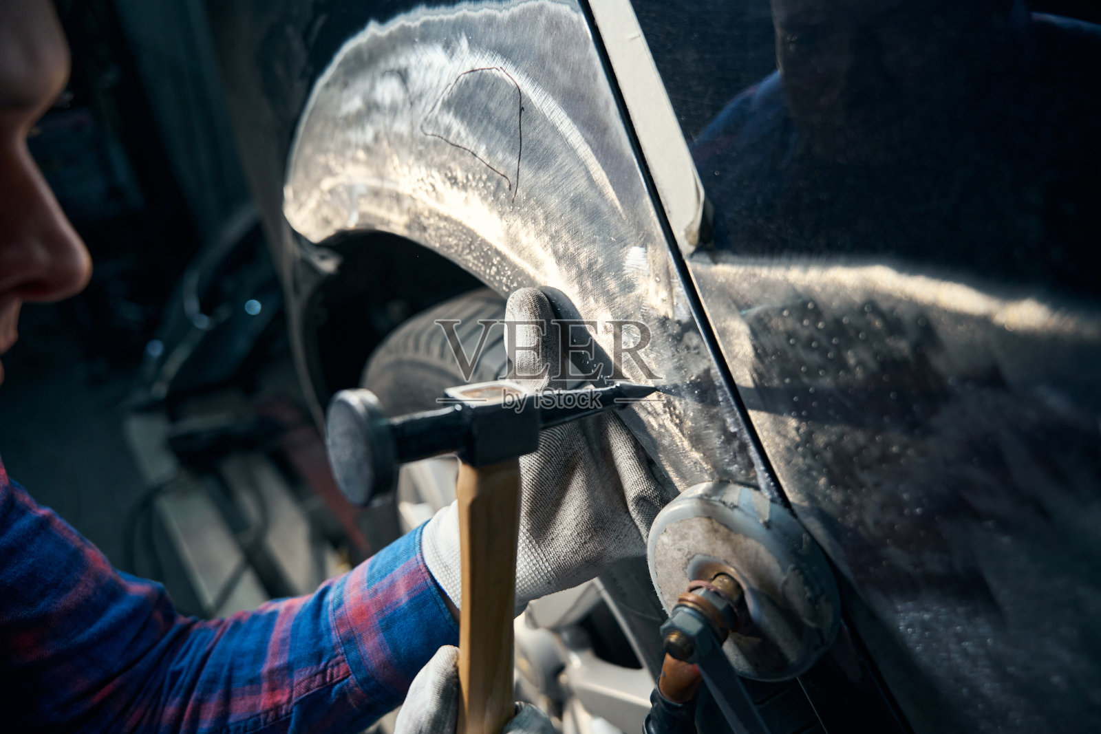 熟练工人用仪器修理前挡泥板照片摄影图片