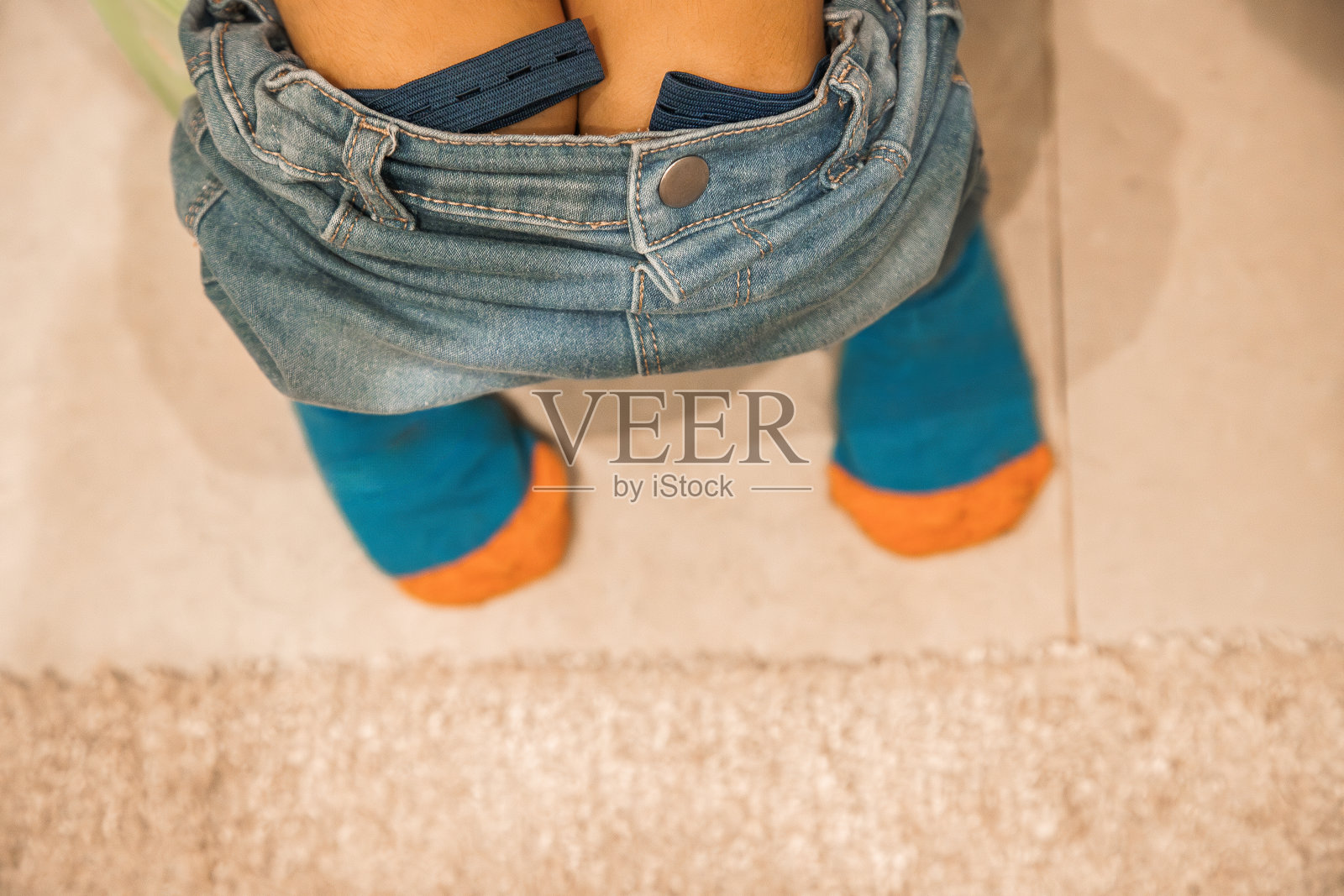 坐在浴室塑料便盆上的小孩。获得生理技能的概念。关闭并复制空间。从上面看。照片摄影图片