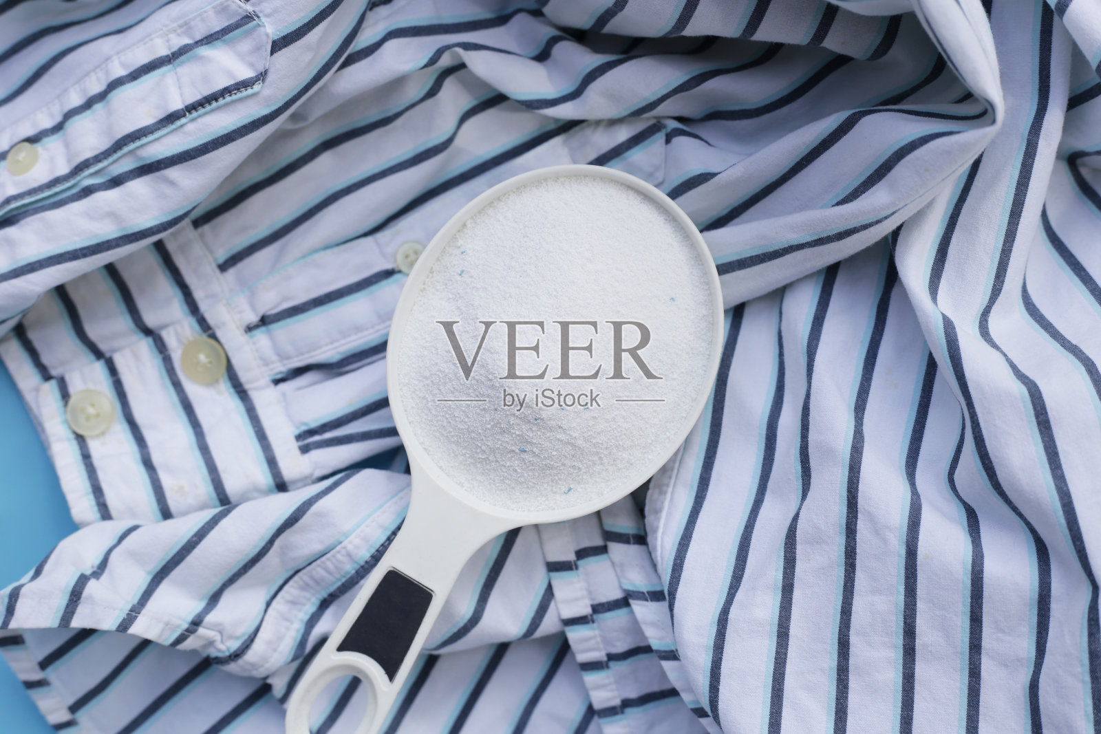 洗衣粉用量勺放在布上再洗涤。衣服的概念。照片摄影图片