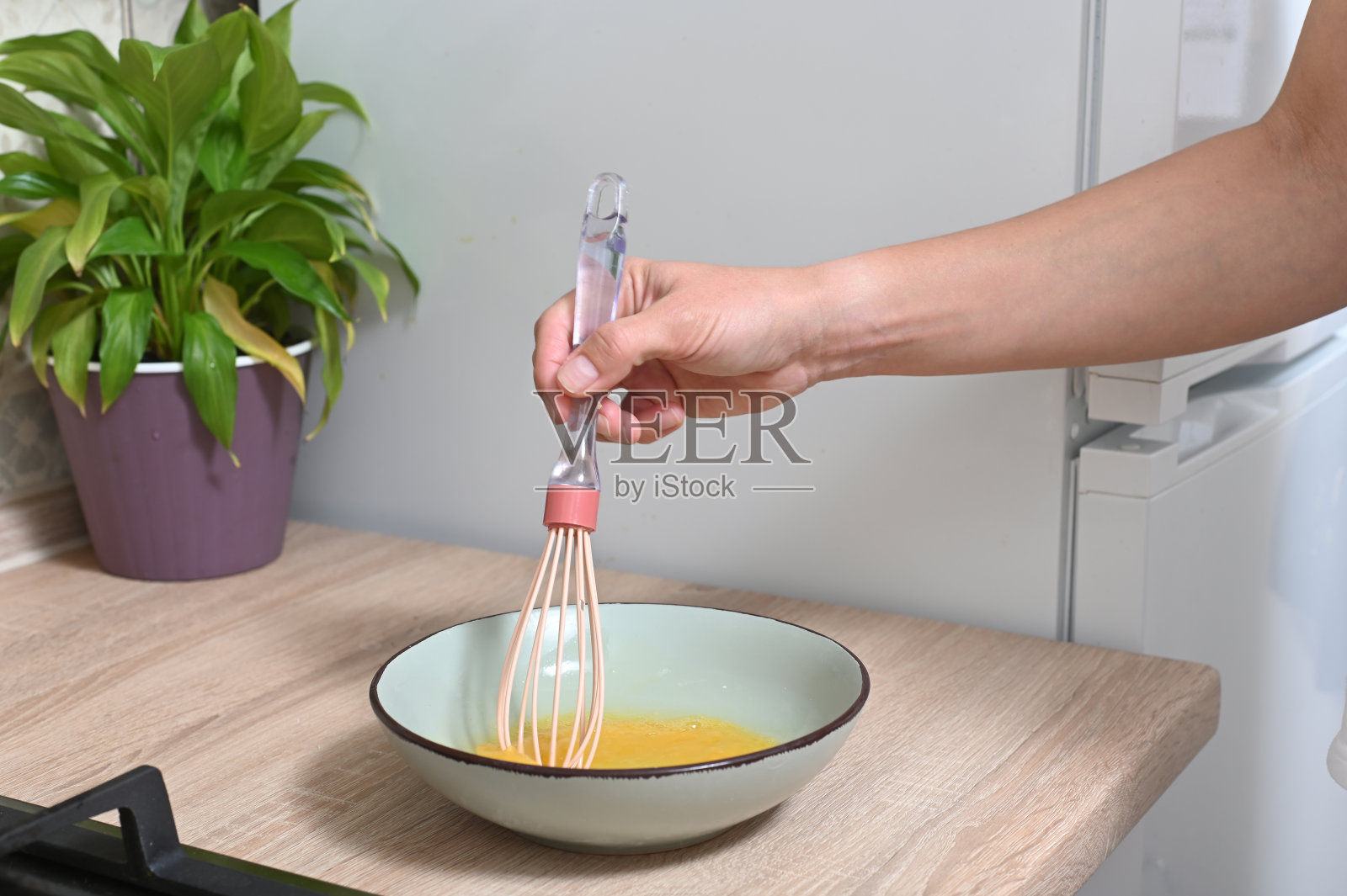 女人打碎鸡蛋做煎蛋卷。照片摄影图片