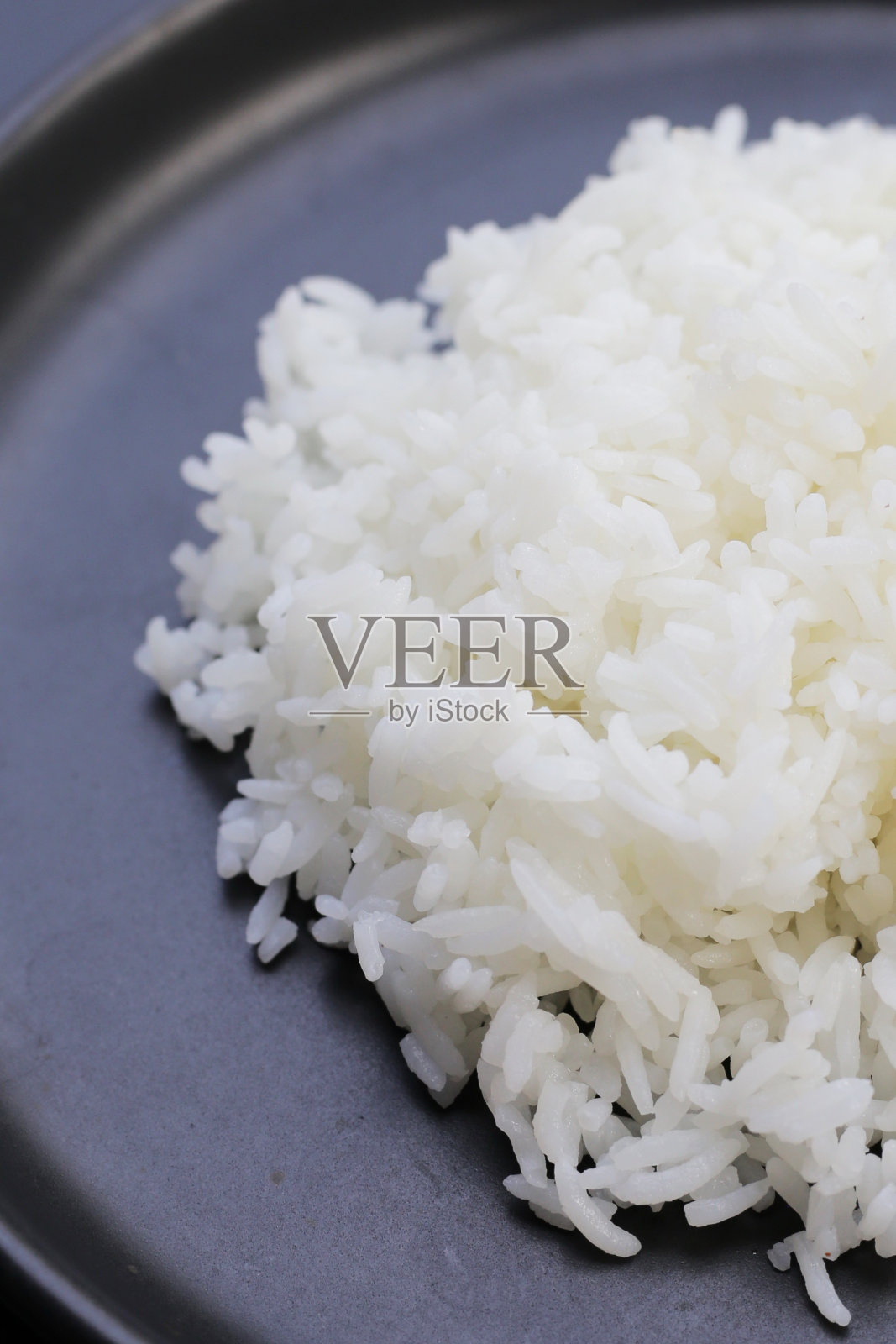 深色背景上煮熟的米饭。照片摄影图片