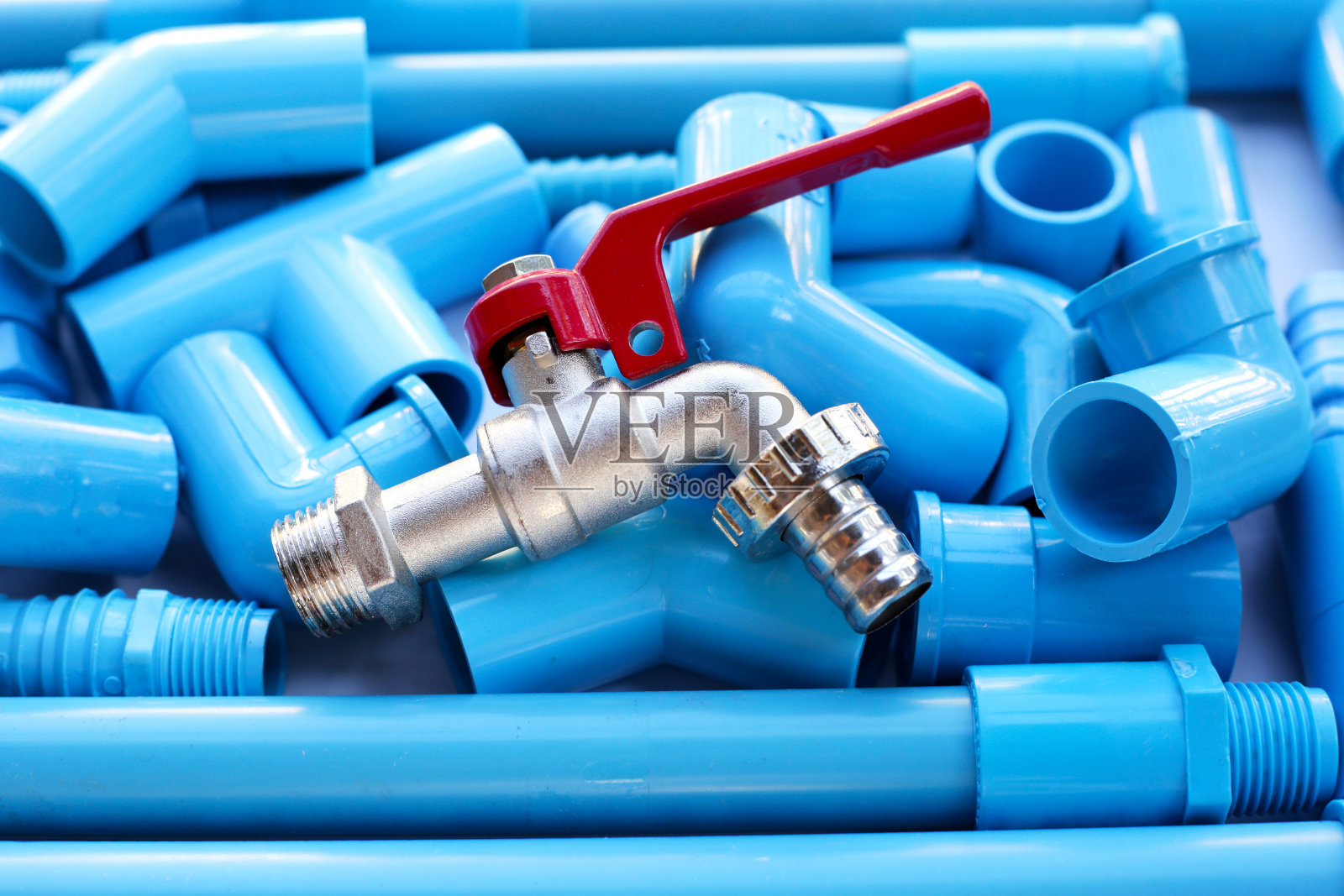 带有蓝色pvc管道连接的水龙头，用于管道工作。水管工设备照片摄影图片