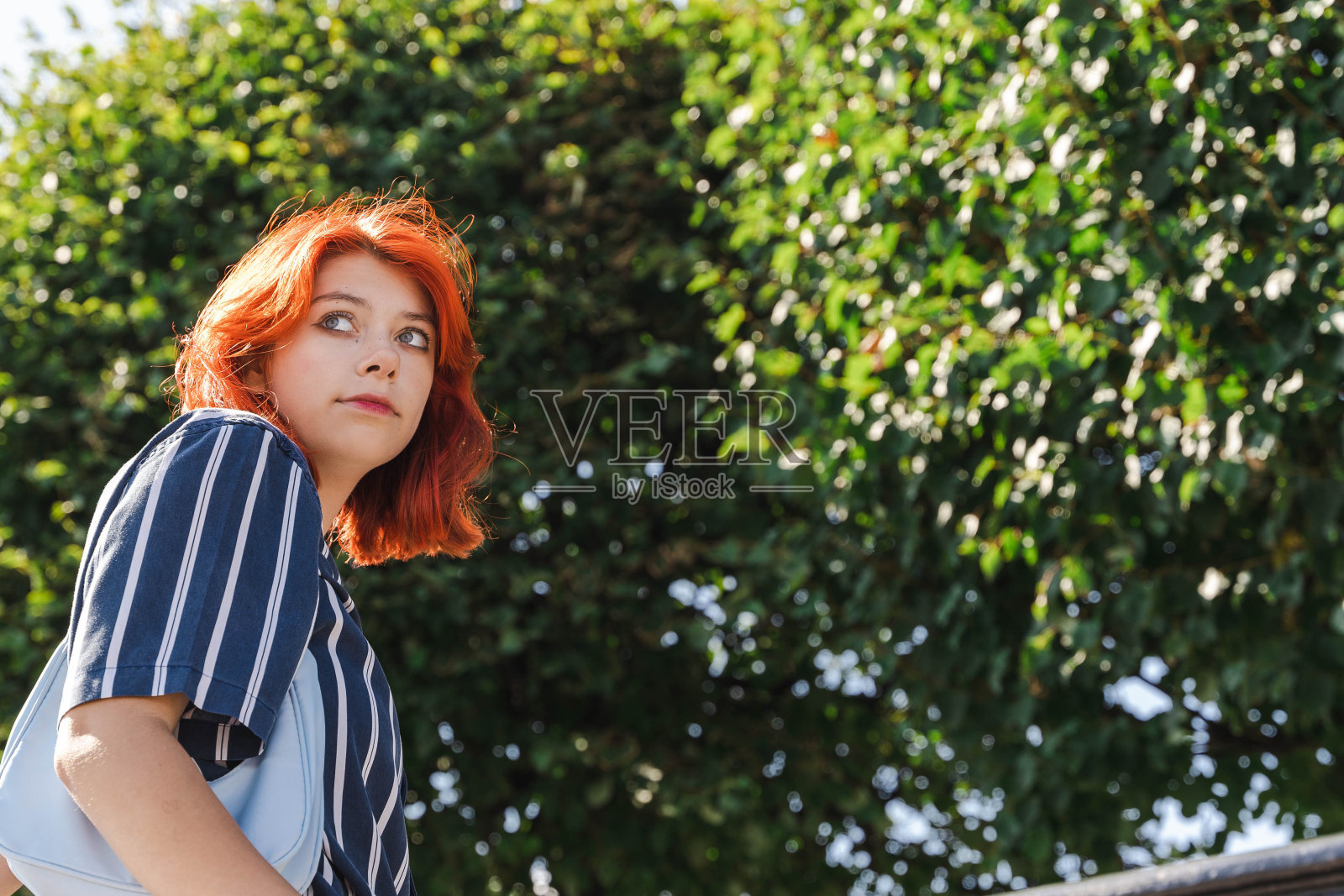 红发Z世代少女在阳光明媚的夏日漫步照片摄影图片