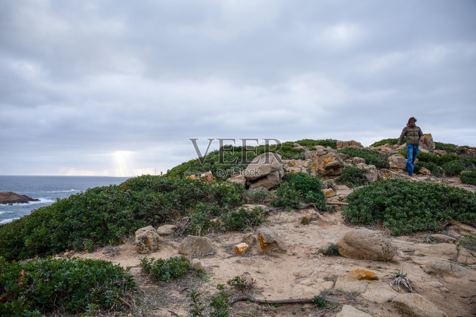 年轻人沿着海面上的山顶散步照片摄影图片