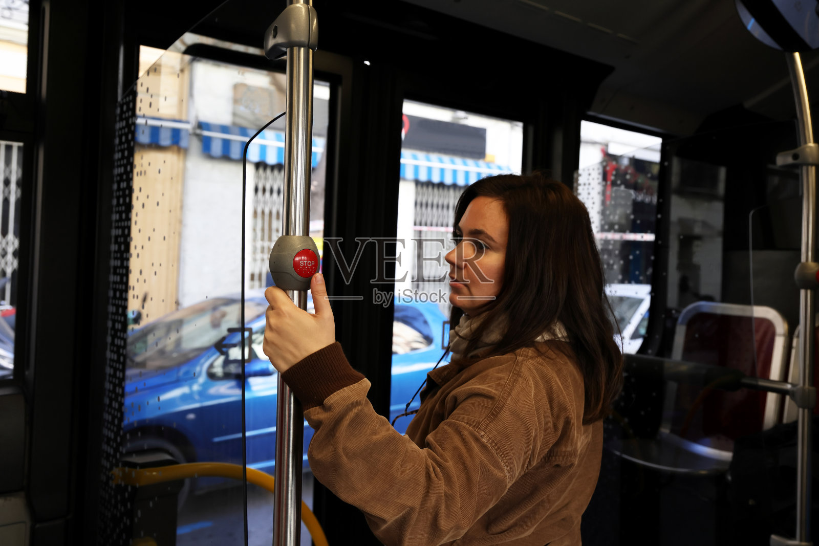 年轻女士正在使用巴士上的停车按钮照片摄影图片
