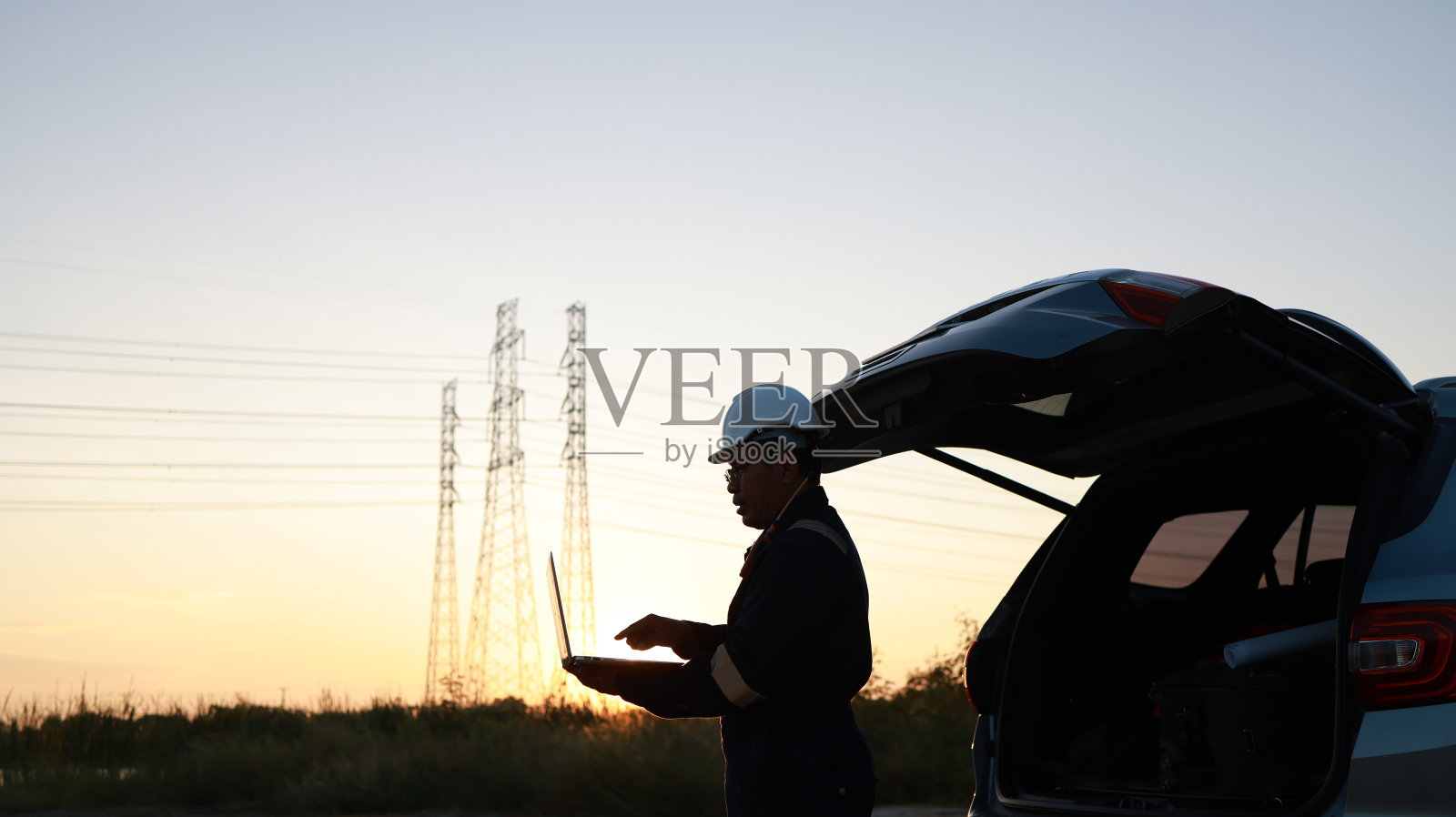 老年电气工程师站在车辆后面使用笔记本电脑在现场项目线照片摄影图片