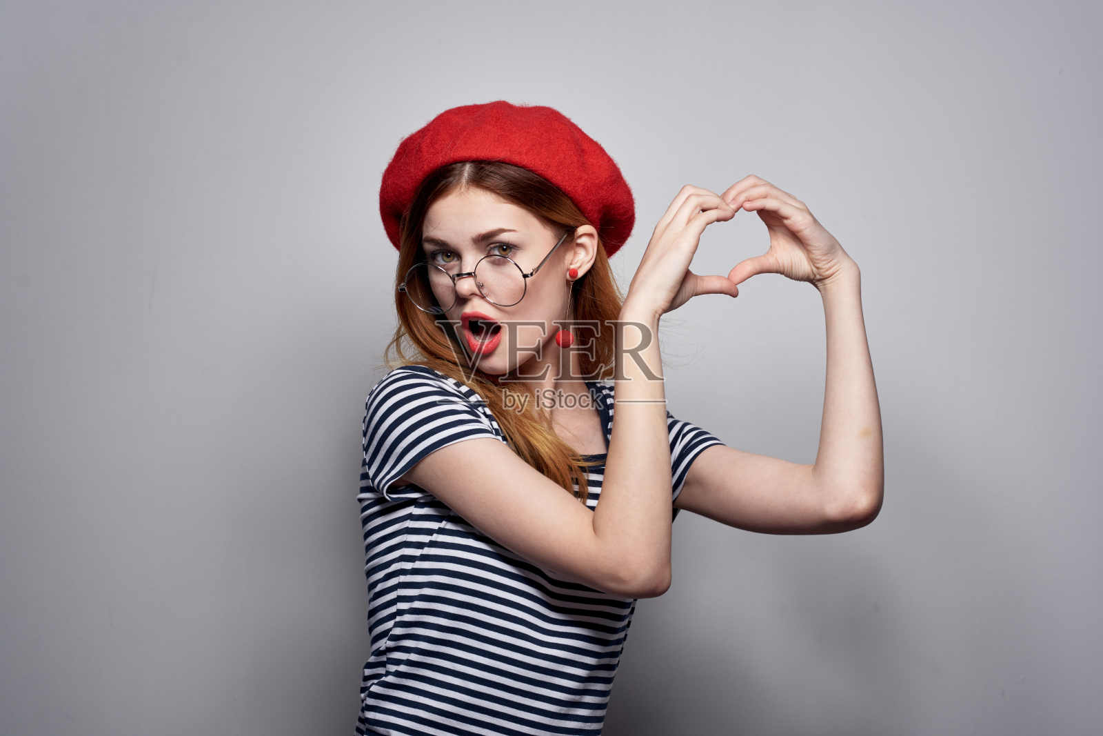 漂亮的女人戴着眼镜摆姿势，时尚迷人，红耳环，首饰照片摄影图片