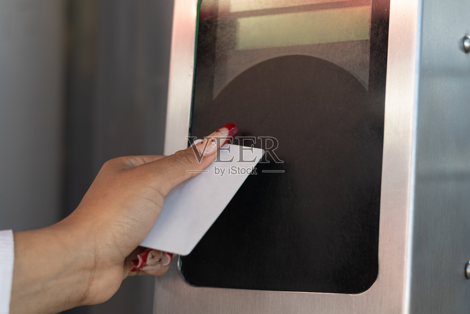 一位正在旅行的妇女的手，在自动控制处用卡支付她的交通费照片摄影图片