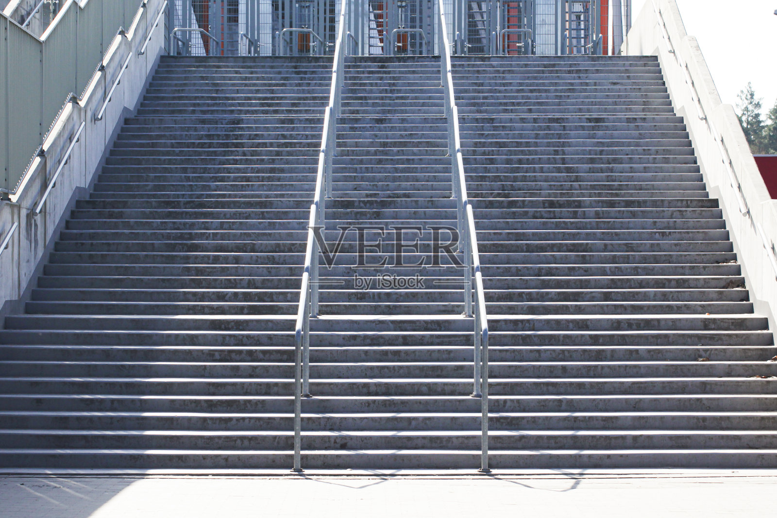 又长又大的水泥楼梯。许多步骤背景。金属扶手。从下面的角度来看。照片摄影图片
