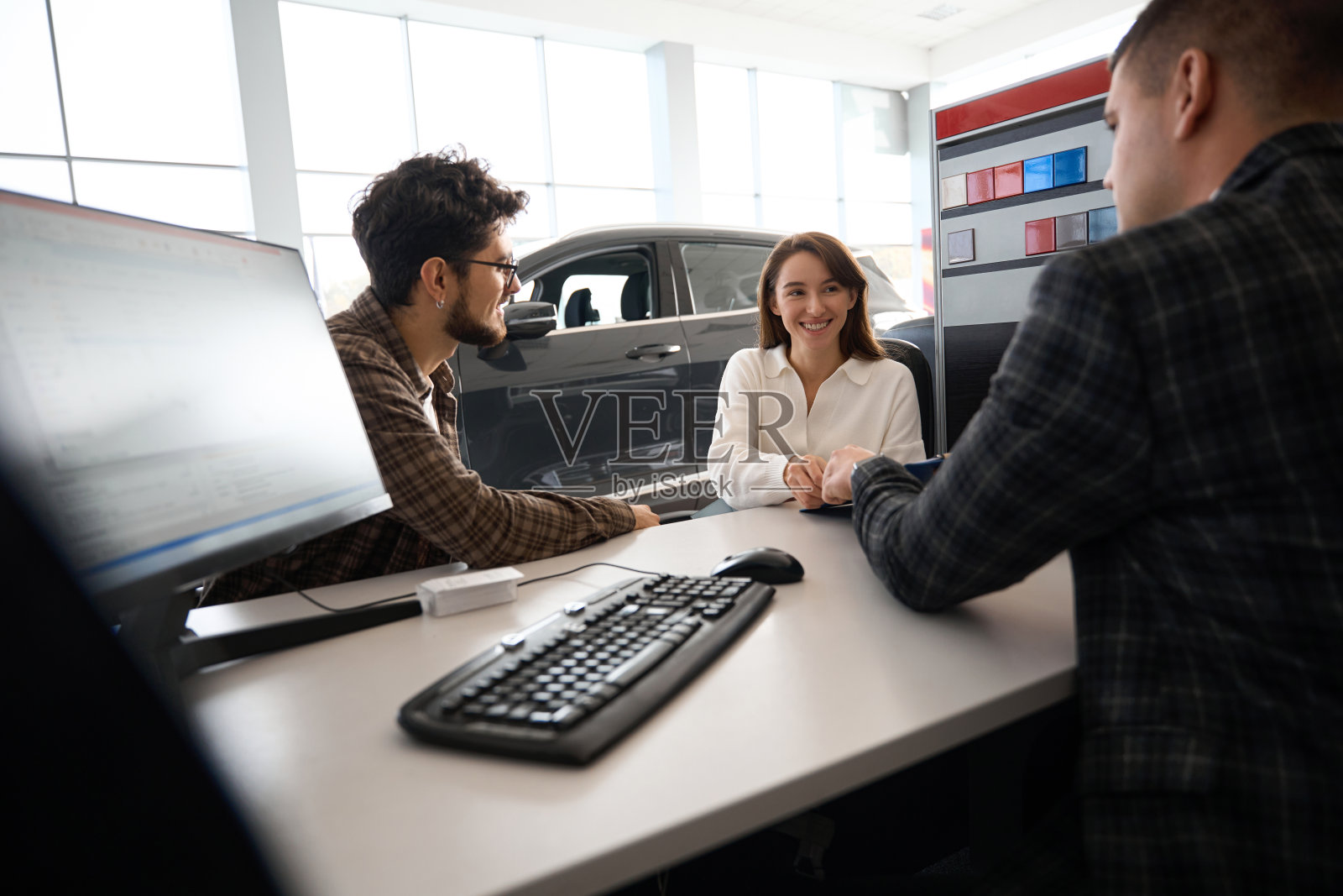一对幸福的夫妇在汽车经销店买新车，与经理讨论租赁事宜照片摄影图片