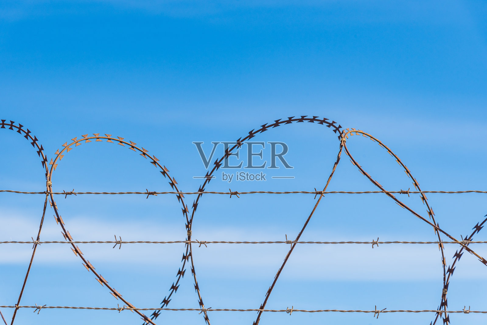 双安全手风琴，一个带尖刺，另一个带刀片，蓝天下，特写。照片摄影图片