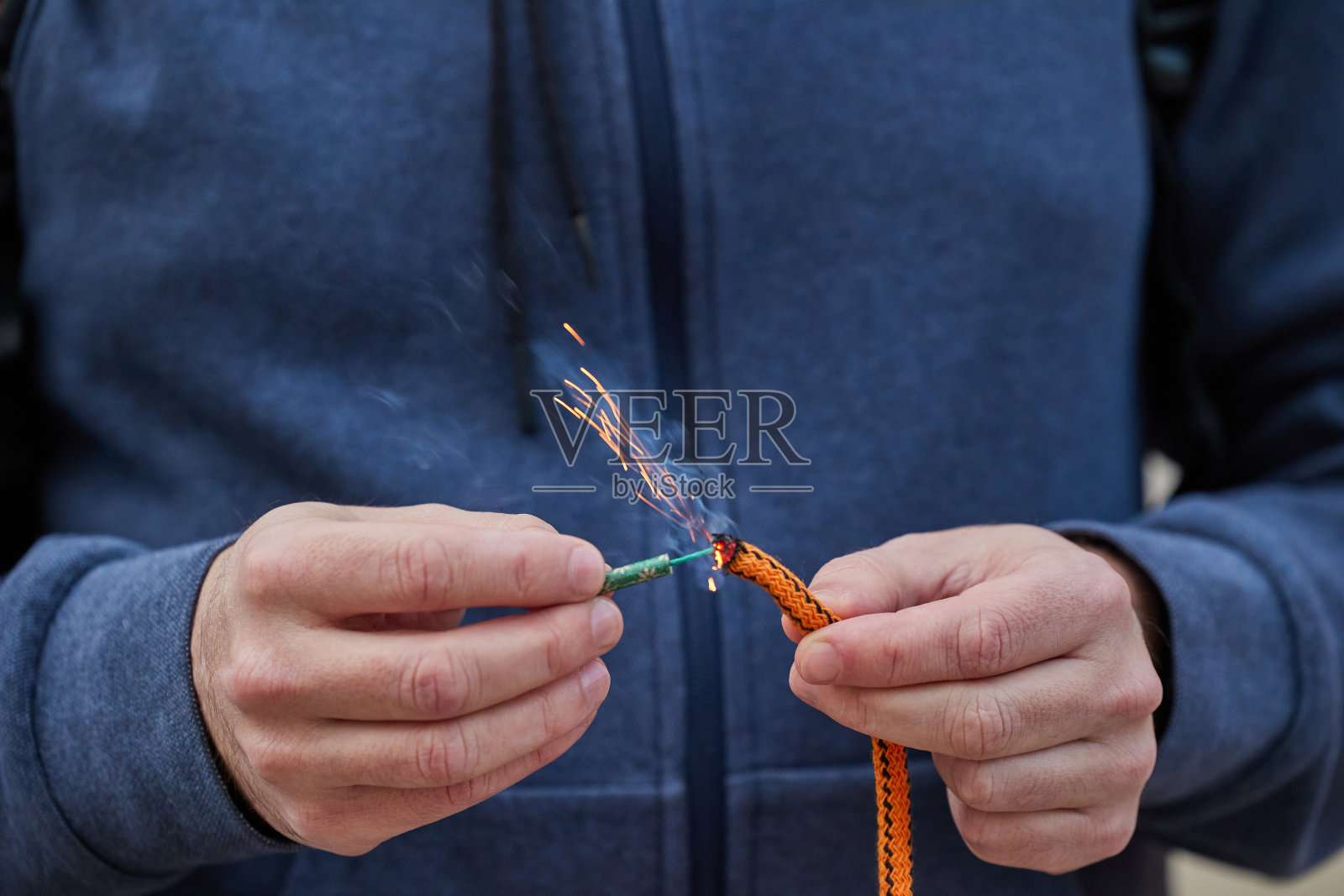 男子用手点燃有灯芯的鞭炮的特写照片摄影图片