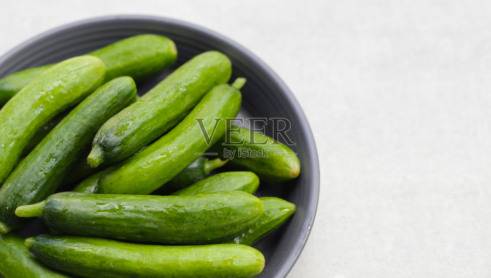 在碗中放入新鲜的迷你黄瓜照片摄影图片