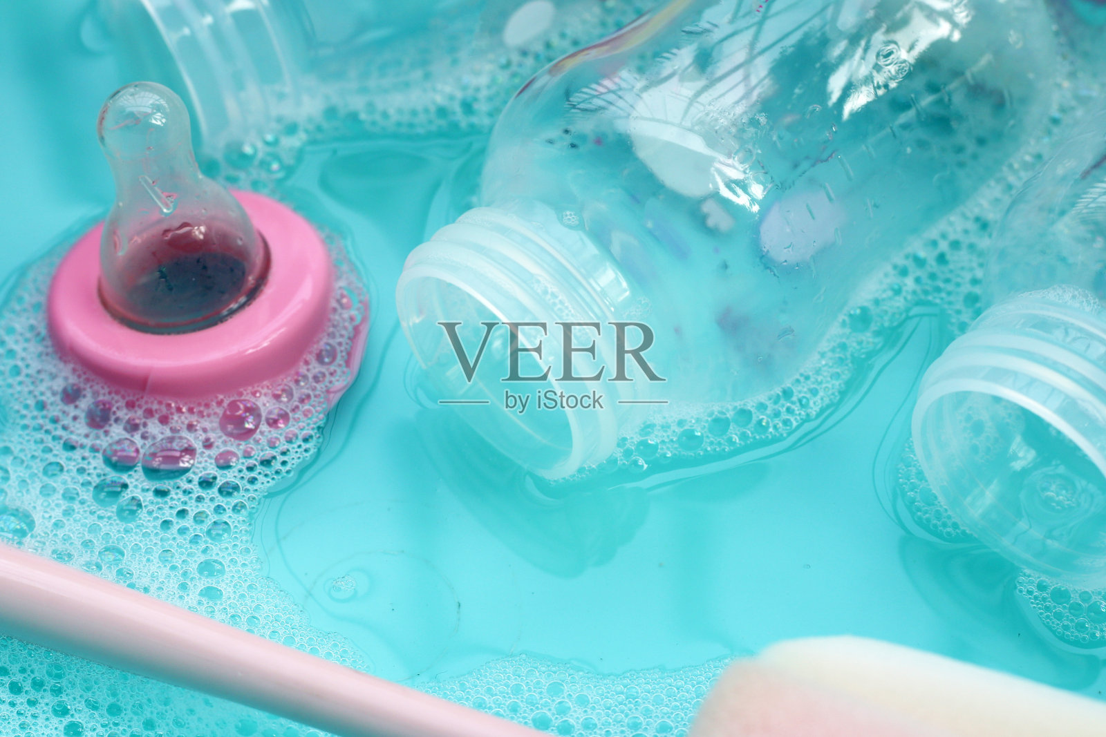 用蓝色塑料盆洗奶瓶照片摄影图片