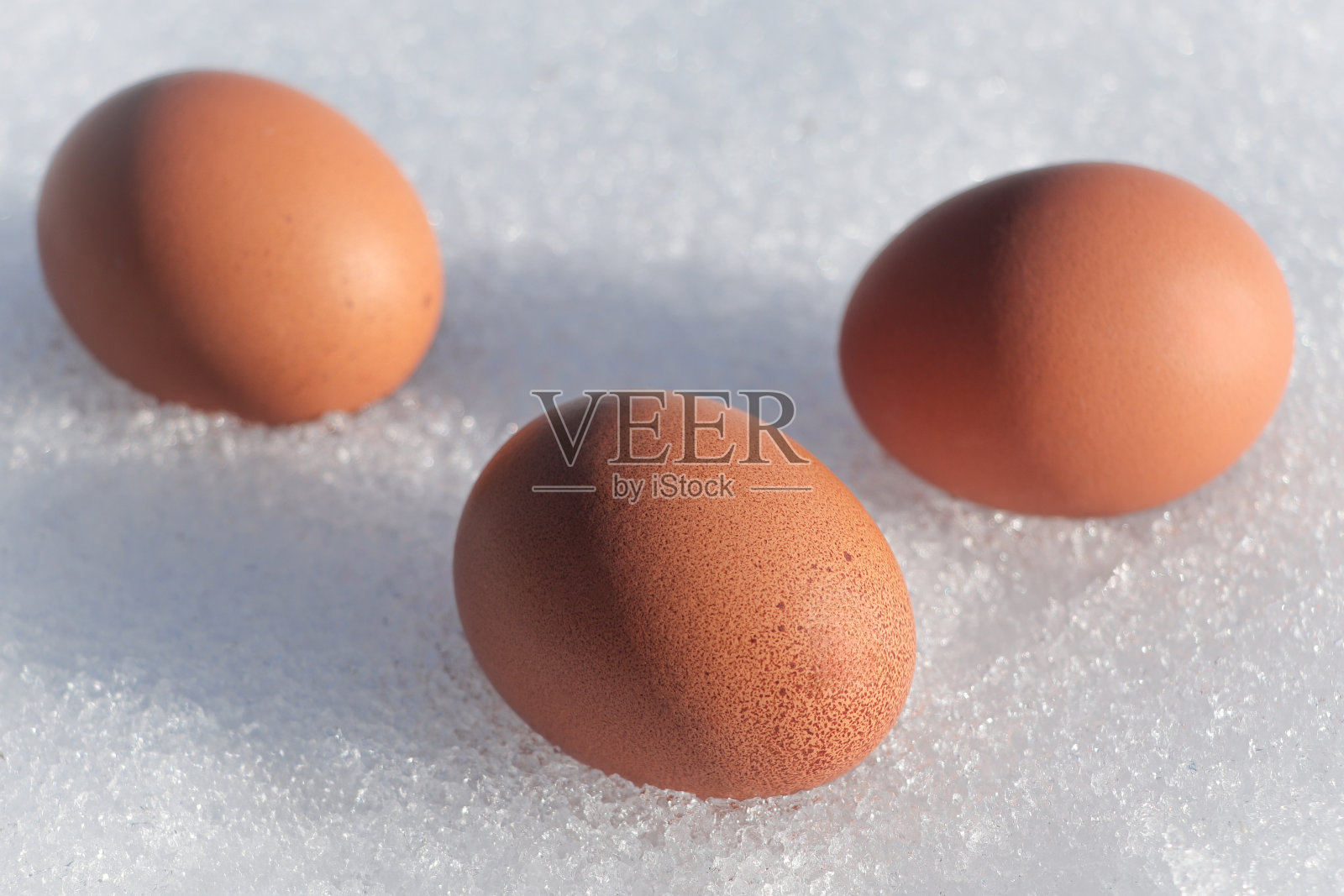 复活节快乐。三个未染色的鸡蛋。自然背景。结霜的新雪照片摄影图片