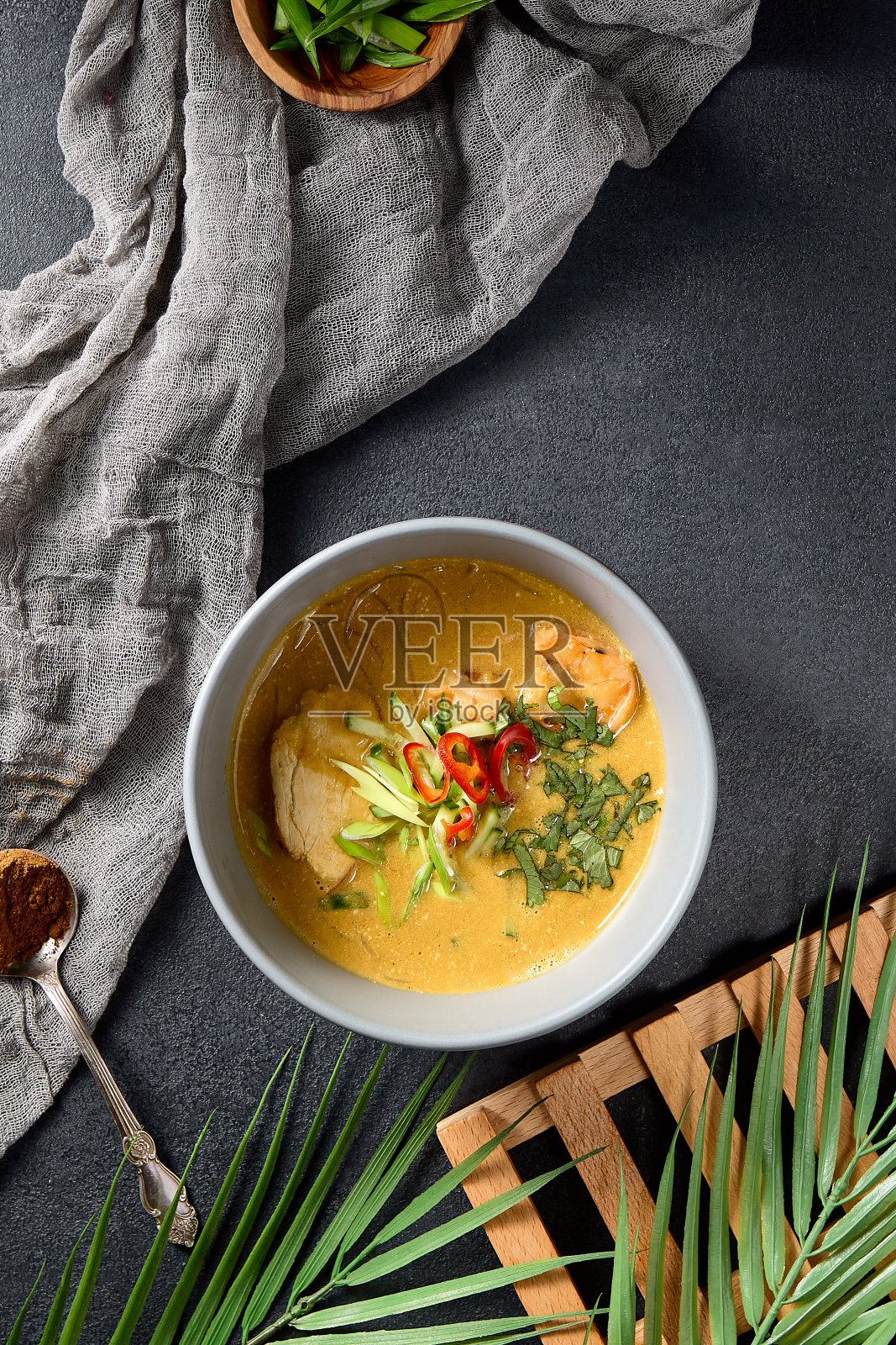 鸡虾咖喱汤，葱和辣椒放在一个白色的碗里照片摄影图片