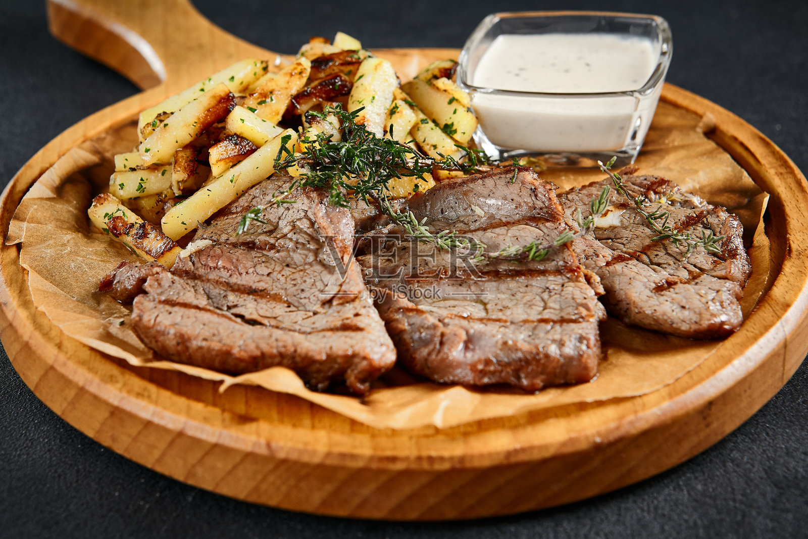 猪排配煎土豆和奶油酱，一道经典的现代菜肴照片摄影图片