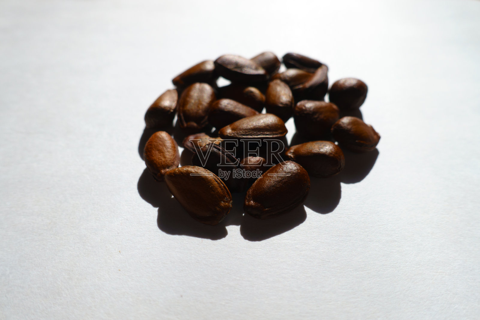 一堆坚硬的、深棕色的、像豆一样光滑的番荔枝种子照片摄影图片