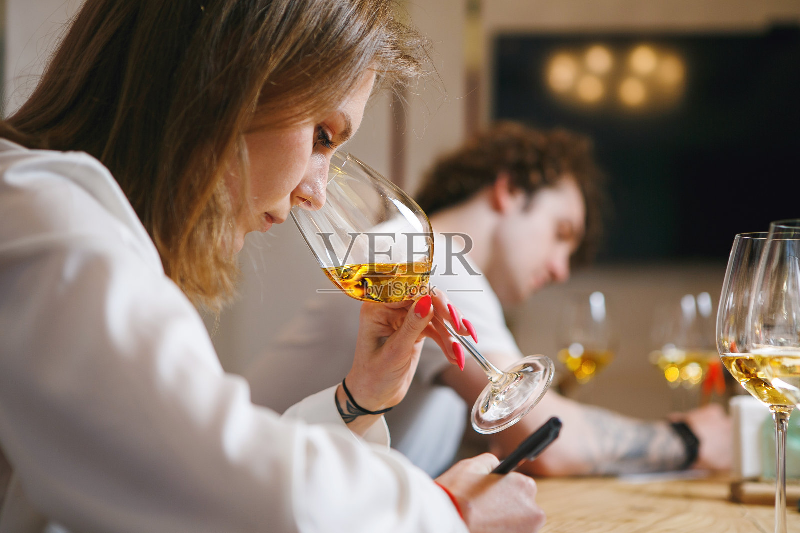 女侍酒师在专业酿酒师考试中品尝葡萄酒。葡萄酒学校，酿酒大师班。照片摄影图片