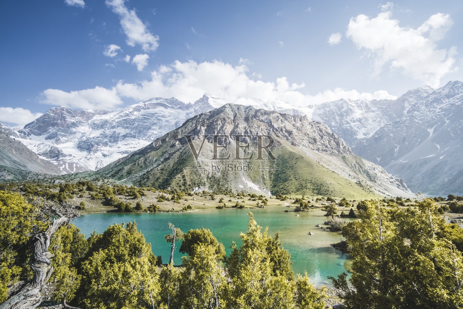 全景山脉和绿松石冷山湖在一个温暖的阳光明媚的晚上在塔吉克斯坦的扇山，天山高原在晚上照片摄影图片
