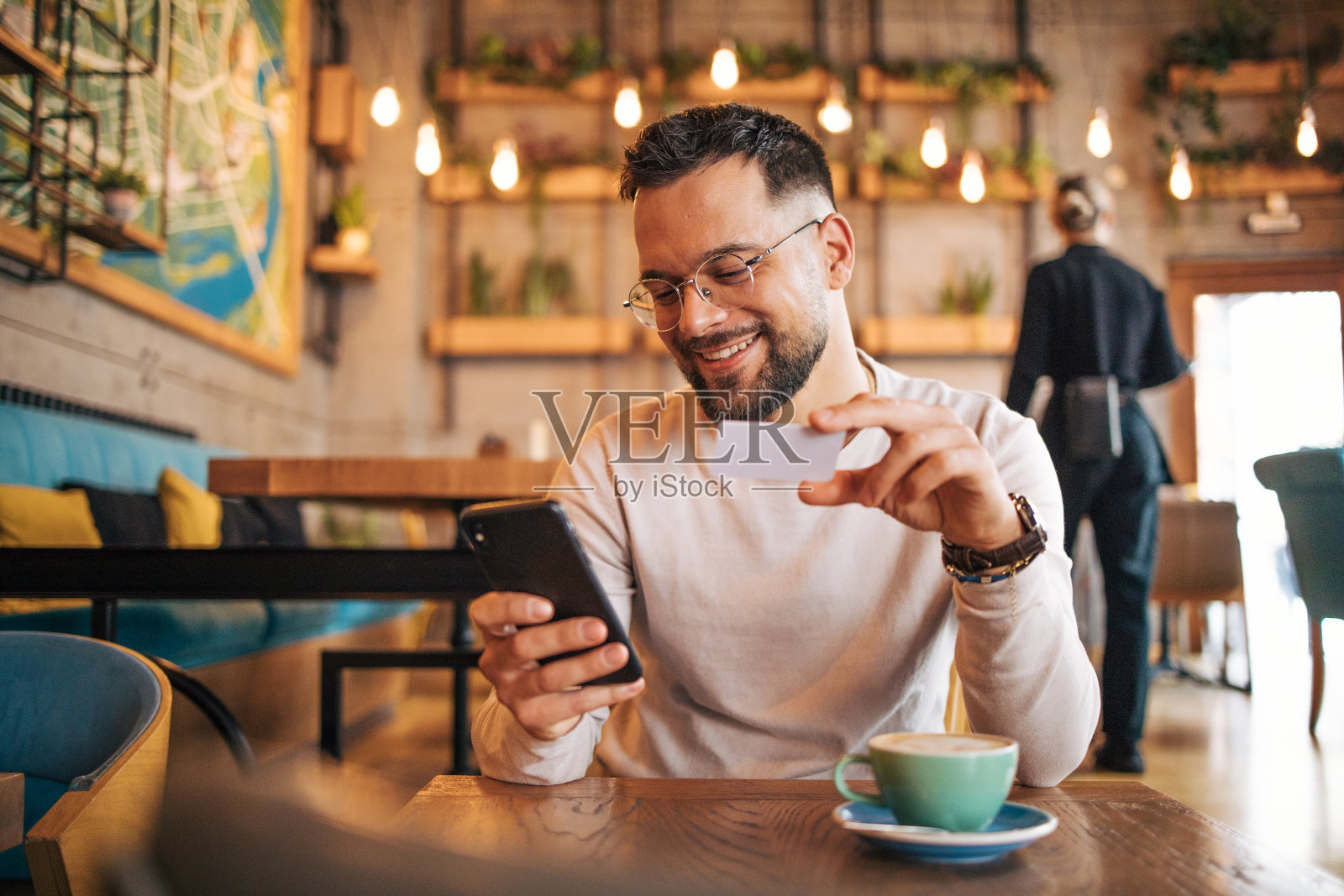 一名男子使用信用卡和智能手机。照片摄影图片