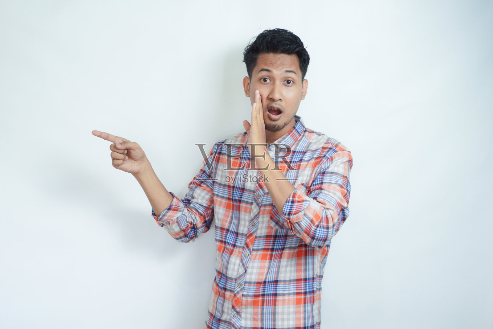 成年亚洲男人在窃窃私语，指着别人照片摄影图片