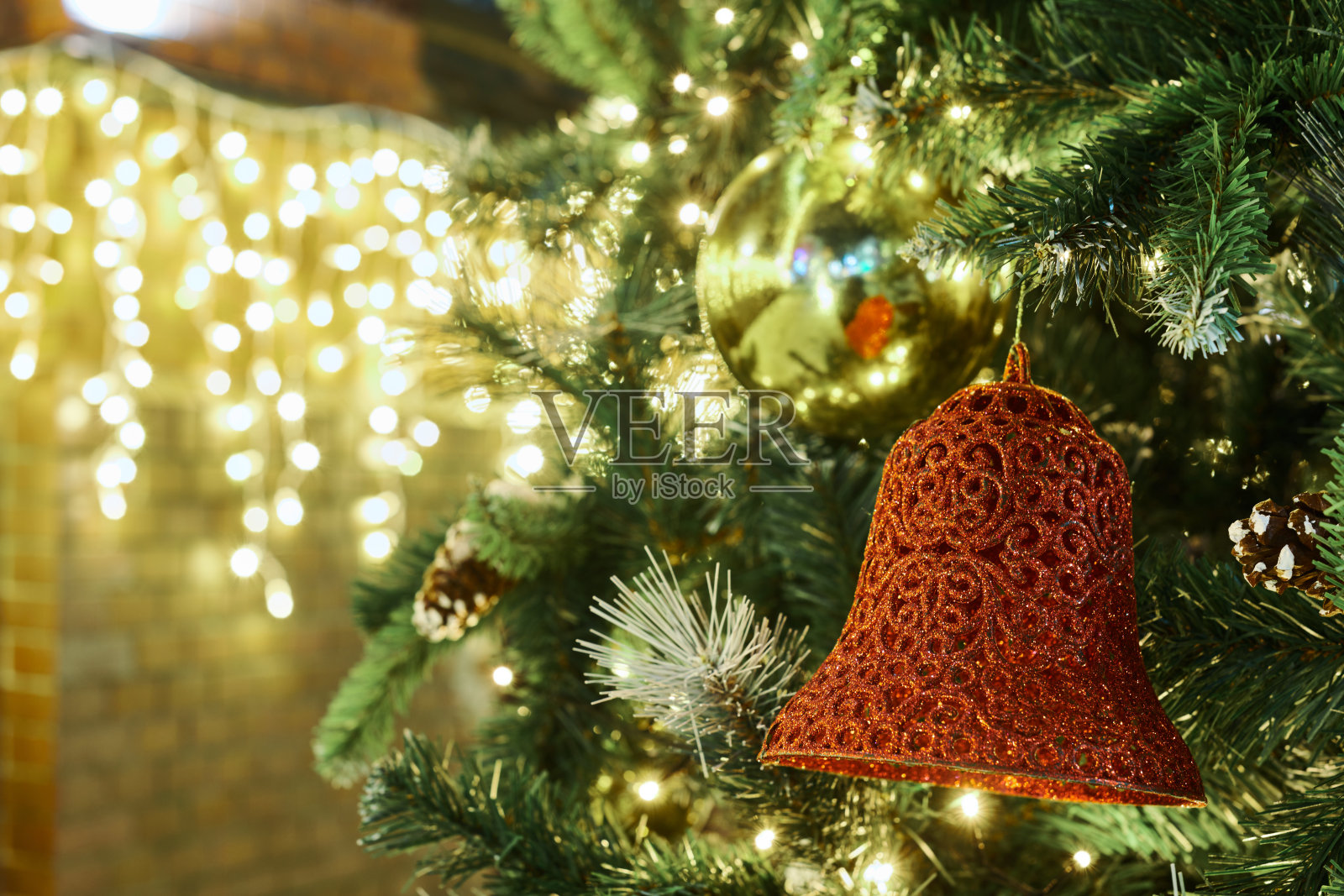 喜庆的新年圣诞树上装饰着红黄色的圣诞球和花环灯照片摄影图片