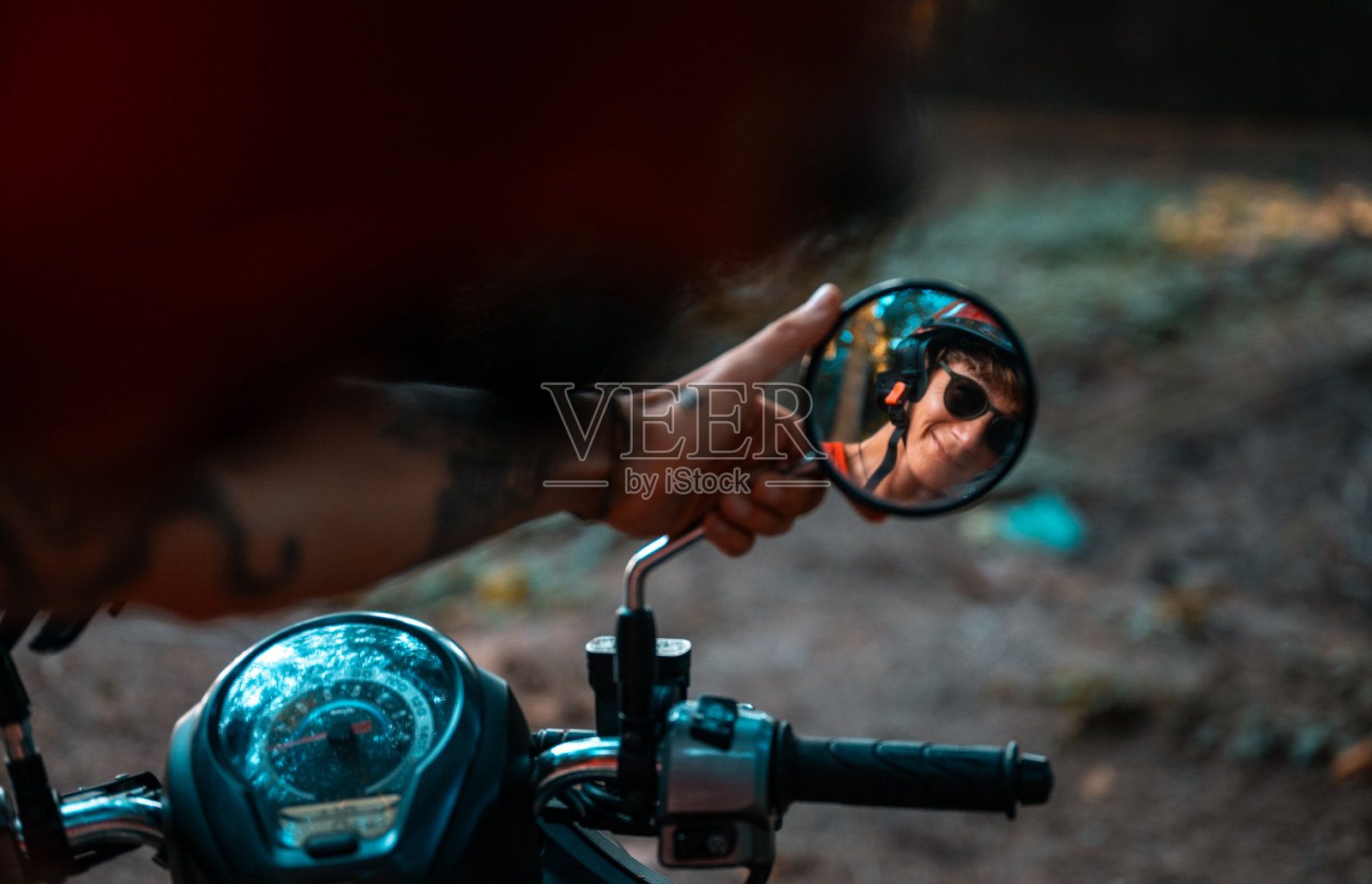 摩托车后视镜里一个年轻人的倒影。照片摄影图片