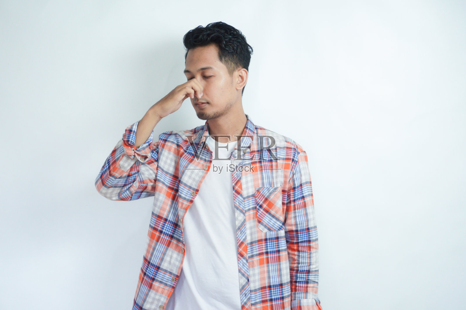 成年亚洲男子闻到不好的气味时用手捂住鼻子照片摄影图片