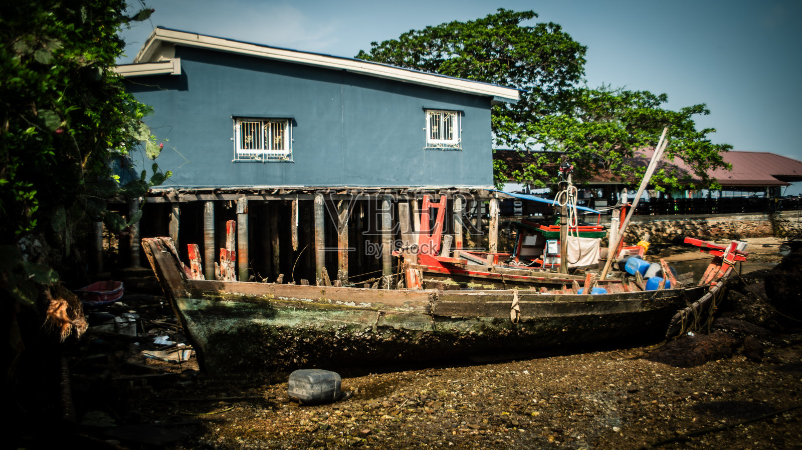 一艘当地渔船的残骸被困在泰国湾海岸的岩石中。照片摄影图片