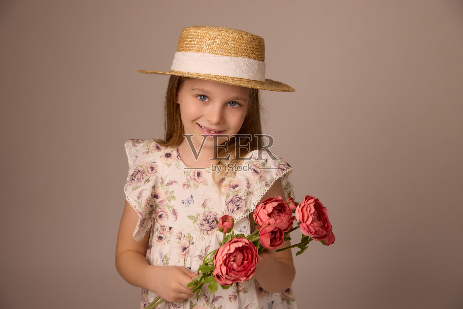 小女孩戴着草帽，手里拿着一束花照片摄影图片