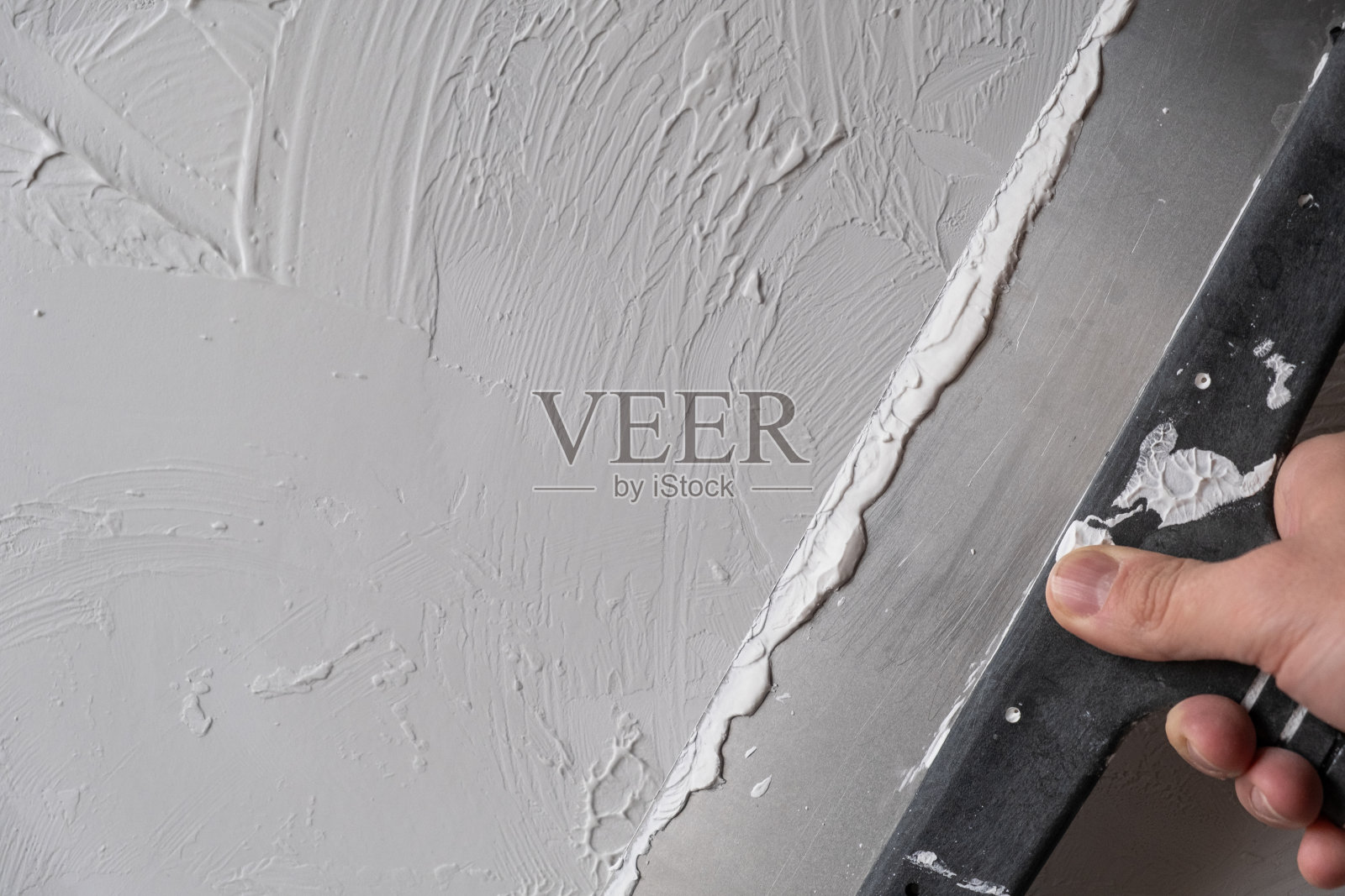 涂抹装饰腻子。白色抽象纹理表面覆盖腻子照片摄影图片