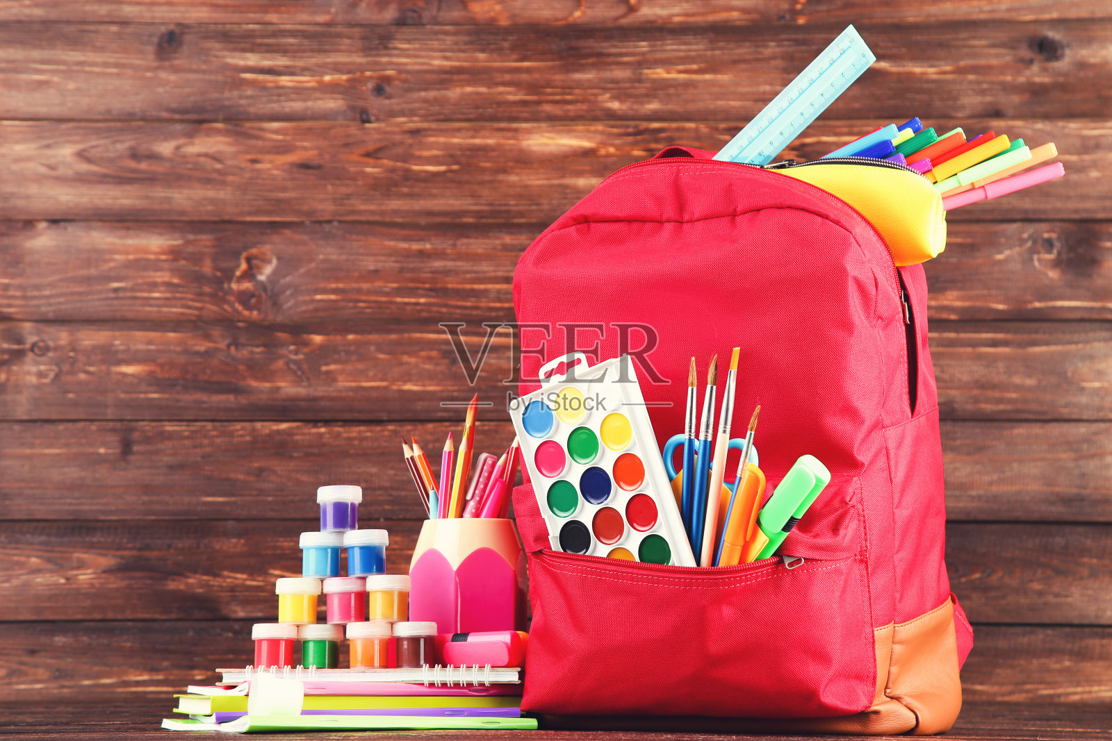 棕色木制背景的书包里有学习用品照片摄影图片