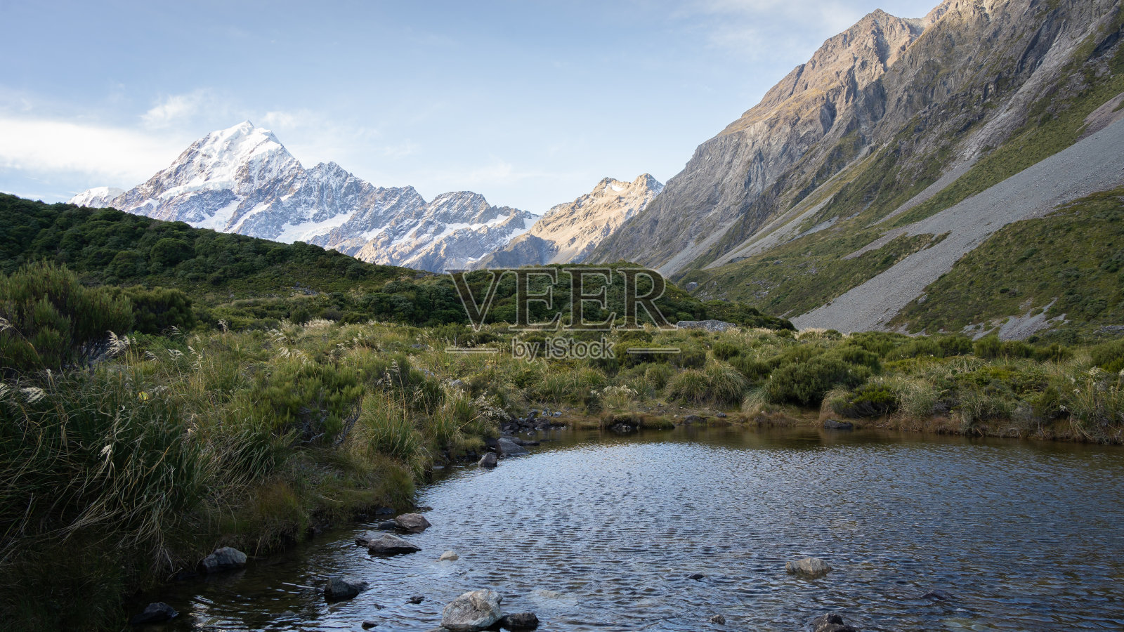 新西兰库克山，小高山池塘，周围群山环绕，背景是雪峰照片摄影图片