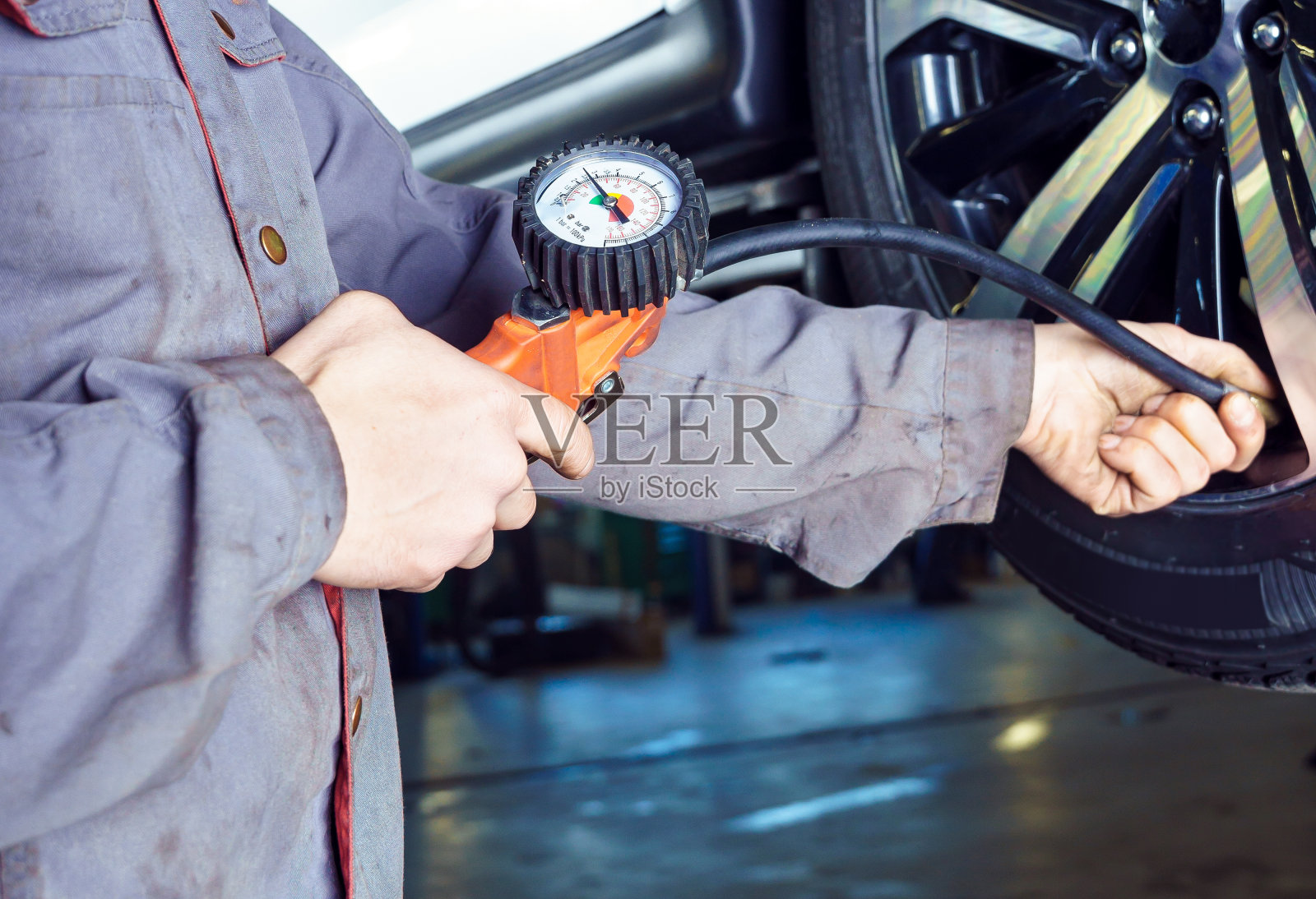 换轮胎和充气，汽车服务和车辆维修。机械式升降机在服务站的提升机上运行。照片摄影图片