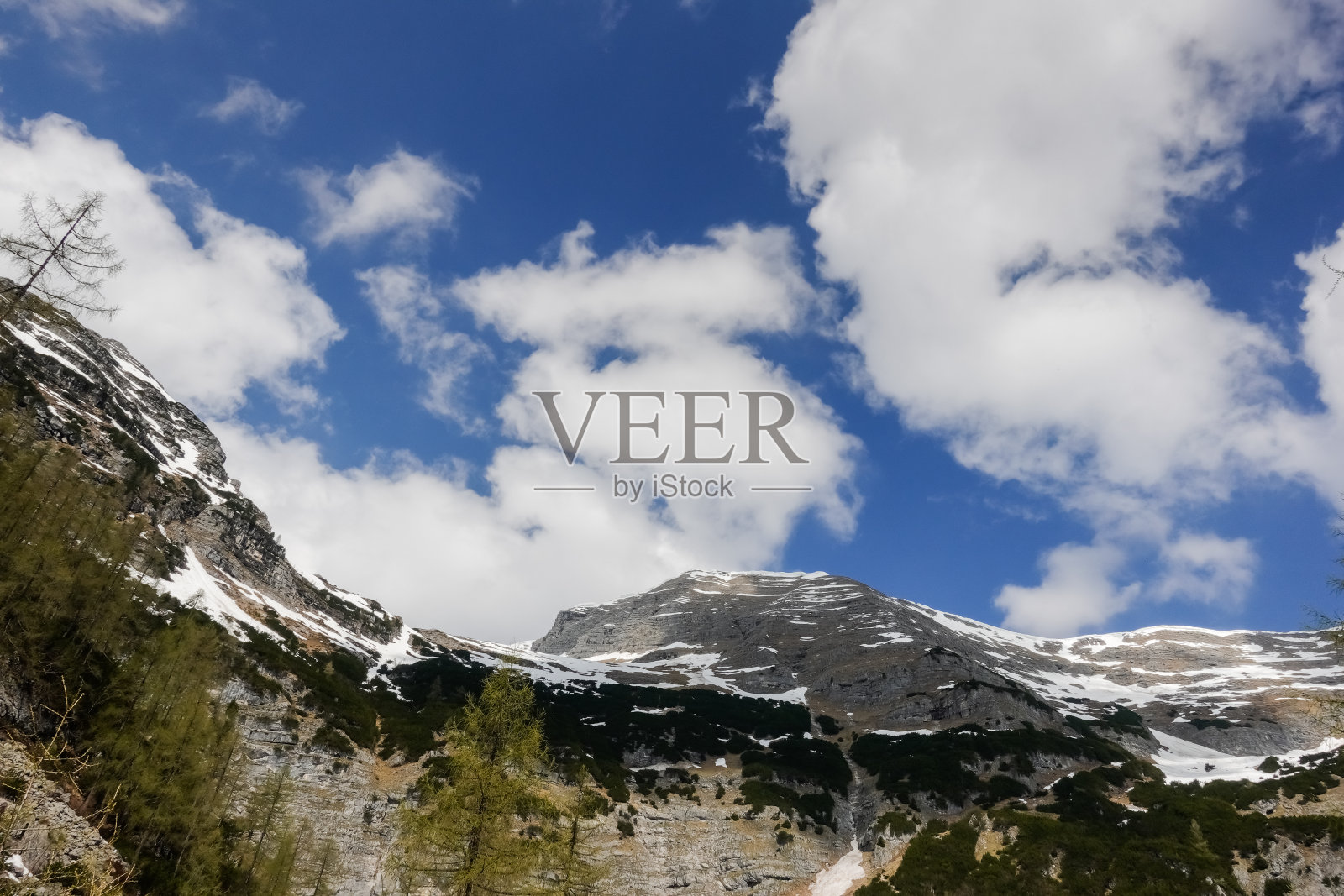 在山上徒步旅行时，可以看到高高的雪山，蓝天上有白云照片摄影图片