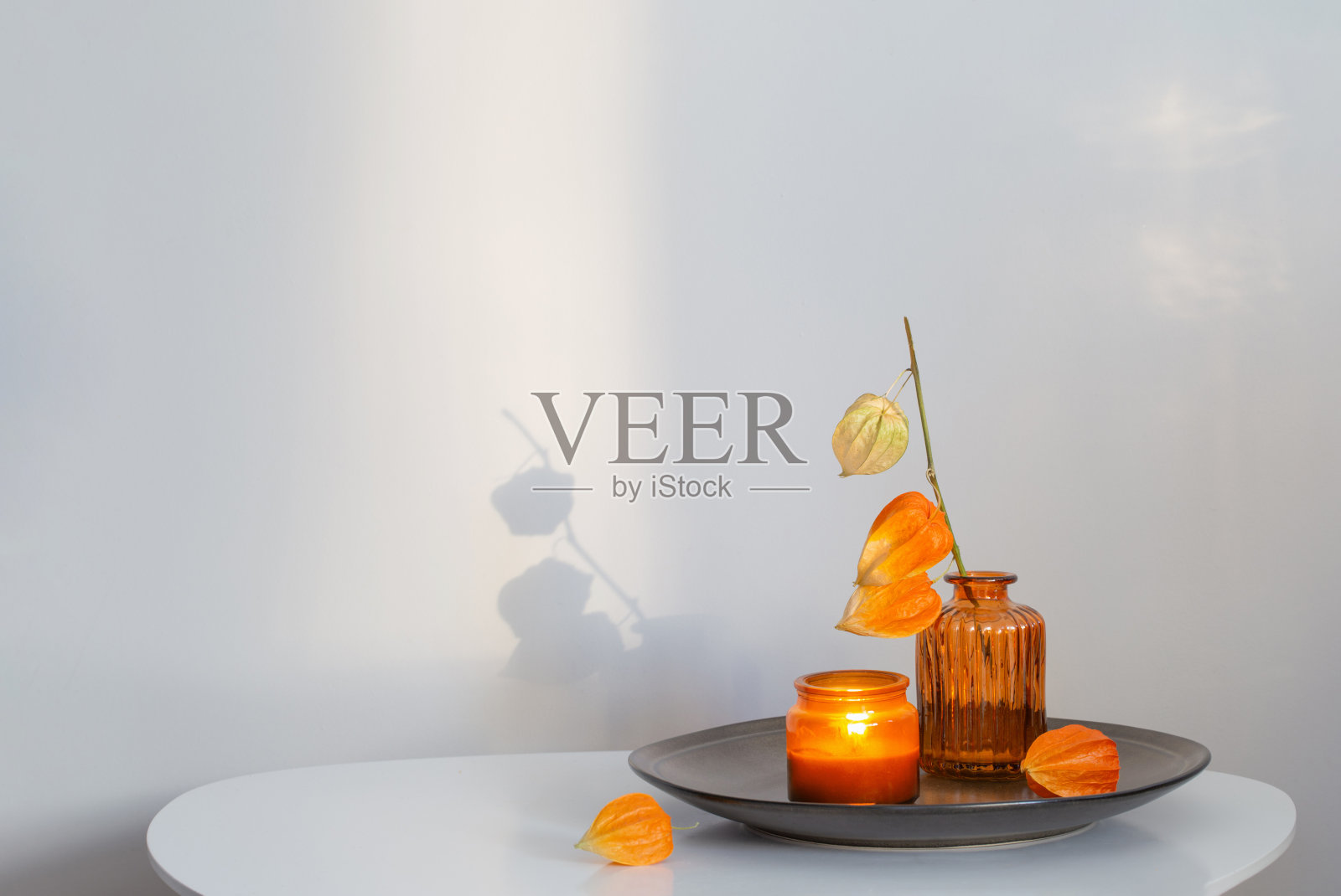 白色桌子上的花朵和蜡烛的秋天静物画照片摄影图片