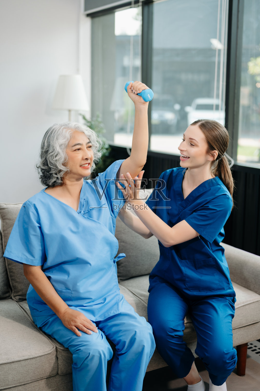 物理治疗师帮助老年妇女患者在运动中伸展手臂，在训练中纠正患者背部问题照片摄影图片