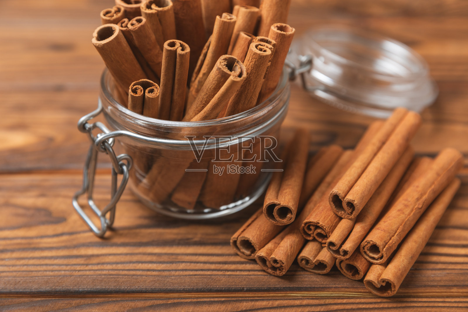 肉桂棒在有纹理的木制背景。肉桂卷。用于烘焙、甜点和饮料的辛辣香料。芳香的肉桂粉。肉桂粉特写。放文字的地方。本空间照片摄影图片