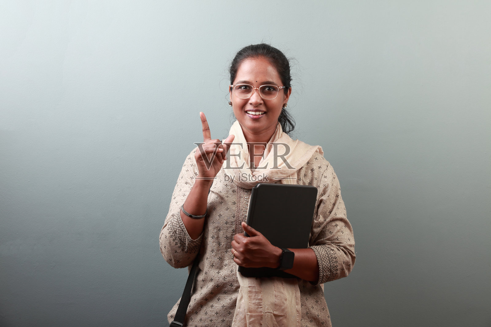 微笑的印度女性拿着平板电脑做手势照片摄影图片