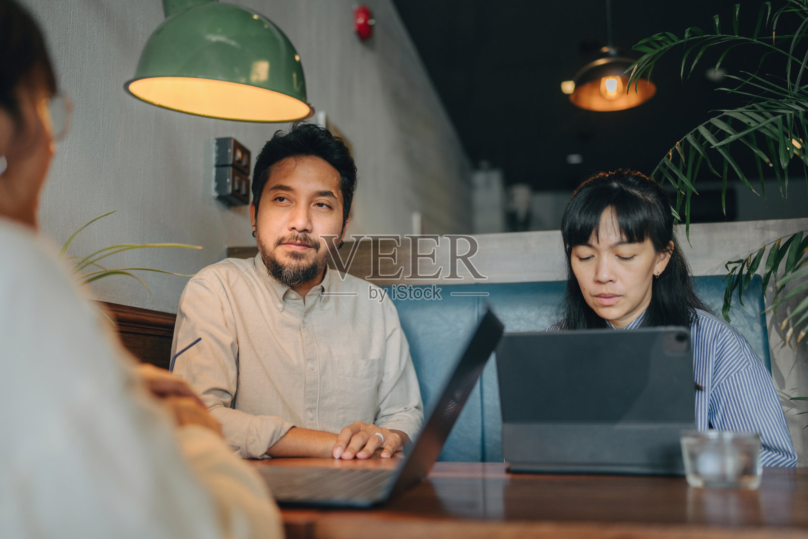 一名穿着休闲装的亚洲男子在餐厅里与同事谈论营销计划照片摄影图片